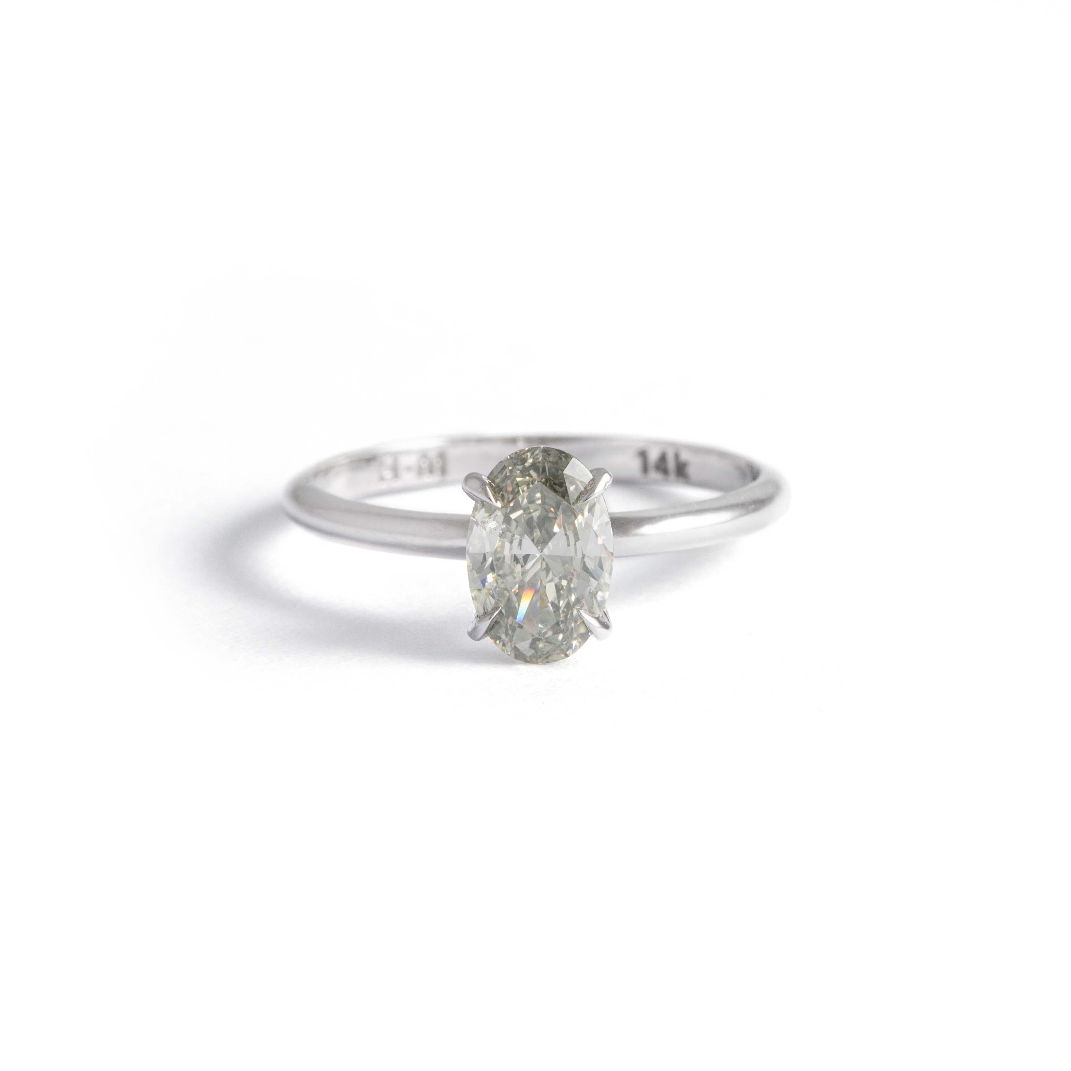 14K white gold solitaire ring centered by an oval-cut diamond weighing 1.10 carat. 
Light Gray color, Vs1 clarity, based on Aig certificate J3210853830.
Gross weight: 1.70 grams.