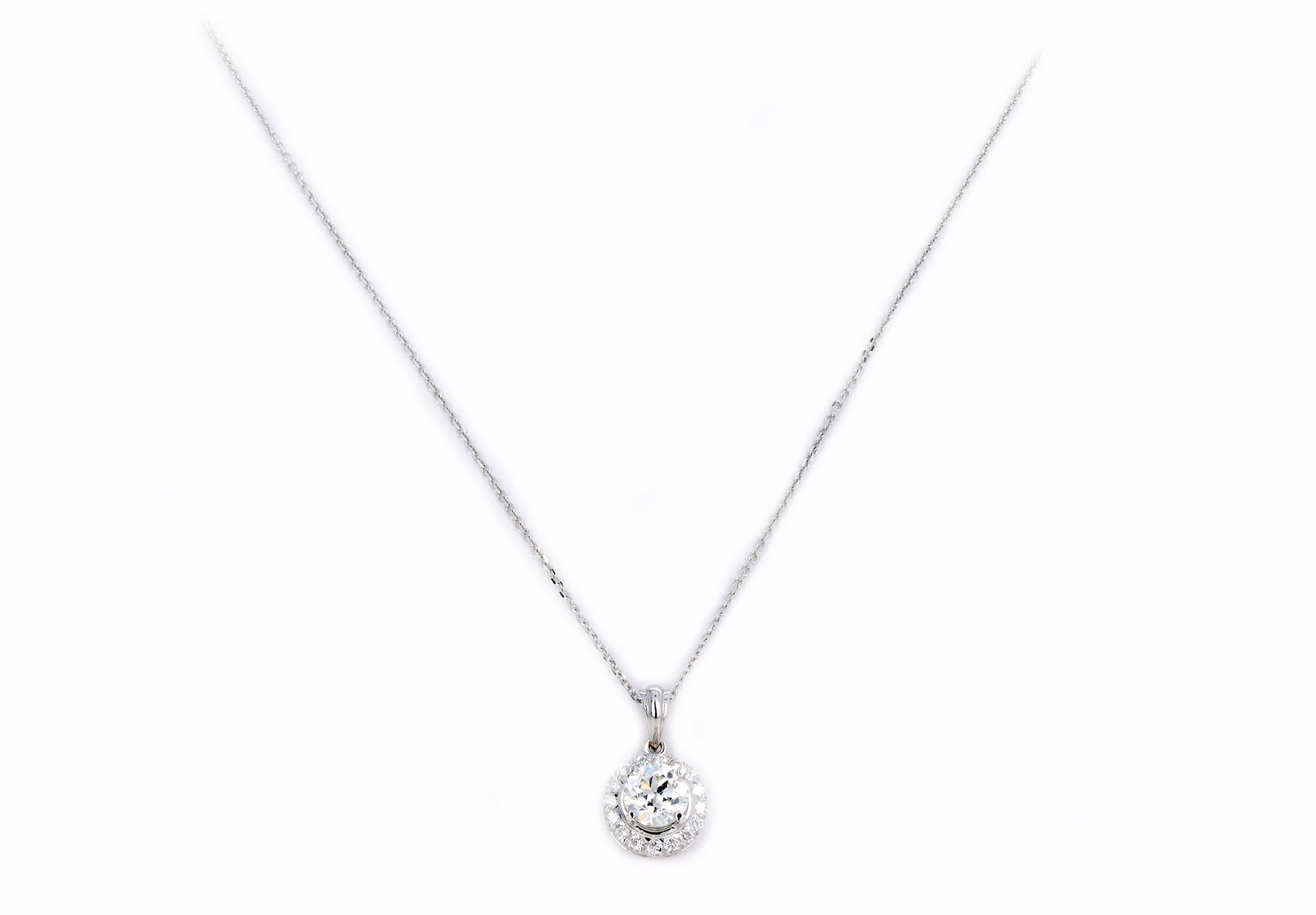 Era: Modern Estate 

Pendant Composition: 18K White Gold

Primary Stone: Old European Cut Diamond

Carat Weight: Approximately 1.10 Carats

Color/Clarity: I / SI2

Accent Stone: Sixteen Round Brilliant Cut Diamonds

Carat Weight: Approximately 0.15