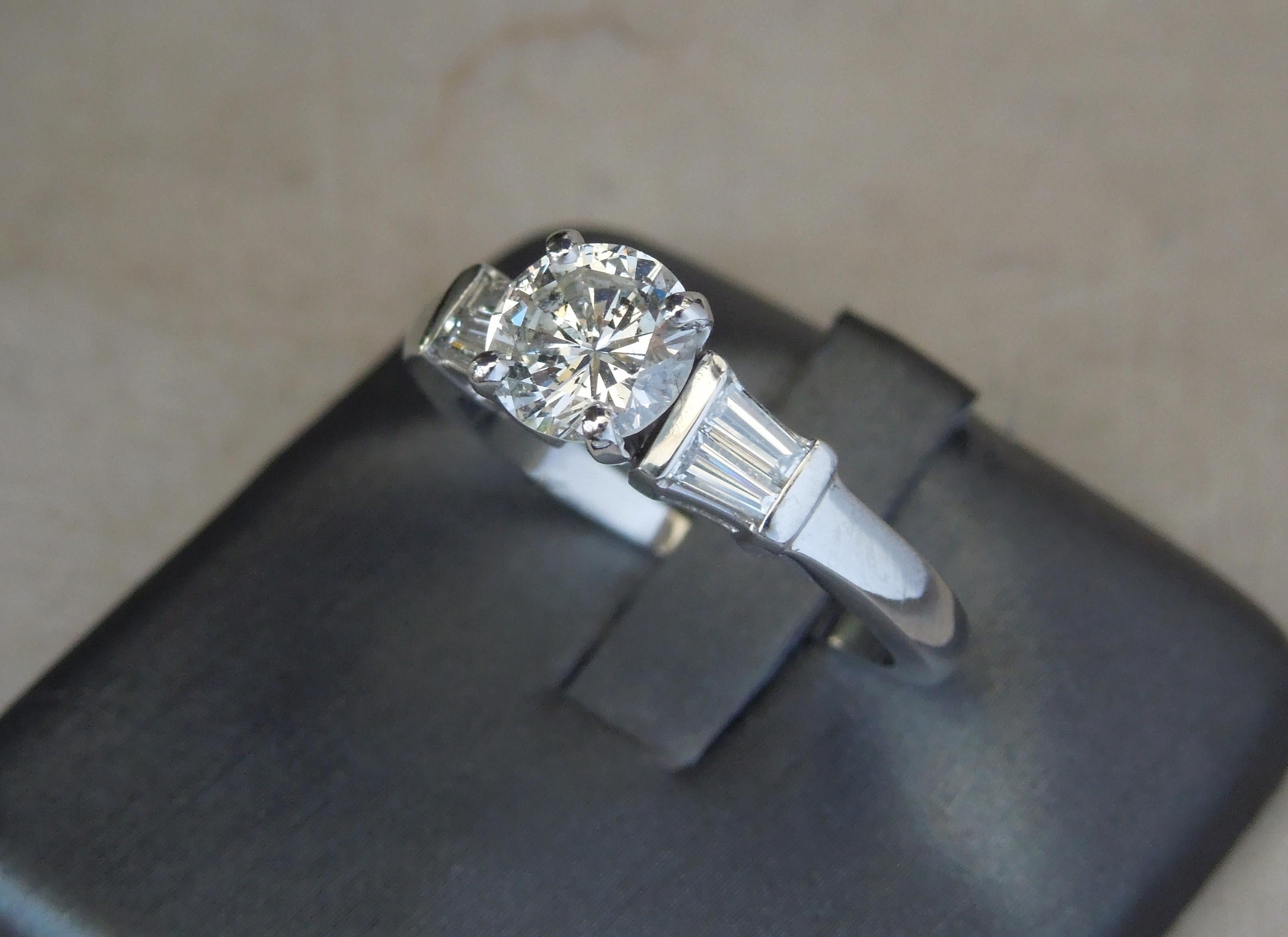 This Classic Platinum Diamond Solitaire features a central Brilliant cut 1.10 carat Diamond at 6.8mm in diameter, ranking an I-J Color & SI2 Clarity. [Although in the I-J range, the Diamond does face up as about a G Color appearing near colorless]