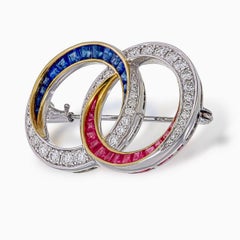 1.10 Carat Round Cut Diamond Brooch with Rubies and Blue Sapphires in 18K W/G
