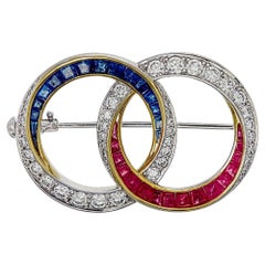 1.10 Carat Round Cut Diamond Brooch with Rubies and Blue Sapphires in 18K W/G