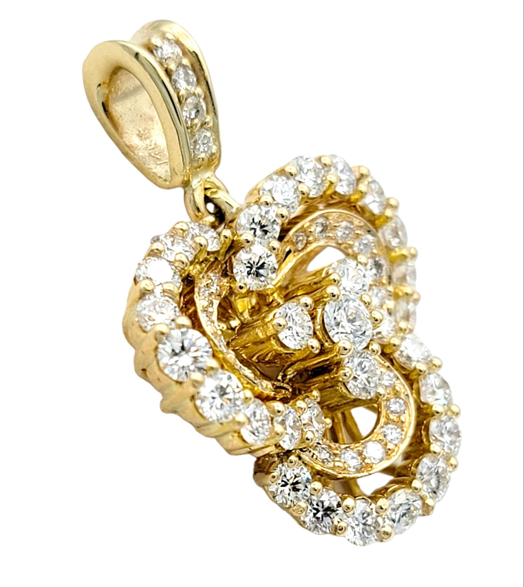 This exquisite diamond pendant, set in resplendent 14 karat yellow gold, is a captivating embodiment of nature's elegance, resembling the delicate petals of a radiant flower. The pendant features three gracefully curving loops, each adorned with a