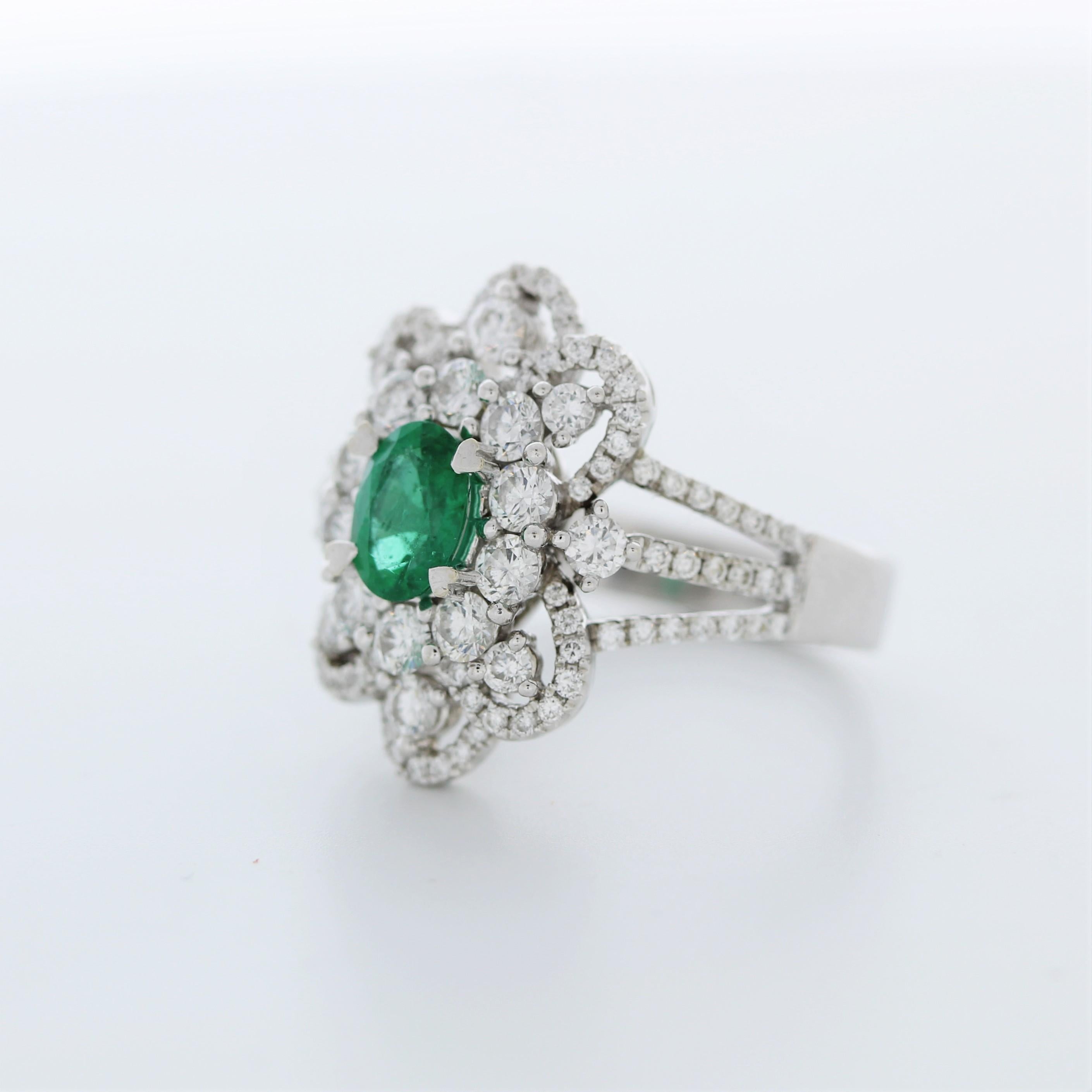 A fashion ring that features an oval-shaped Emerald gemstone set in 14k white gold (14k WG). The Emerald gemstone has a weight of approximately 1.10 carats. The ring also includes round-cut diamonds, with a total quantity of 108 diamonds.