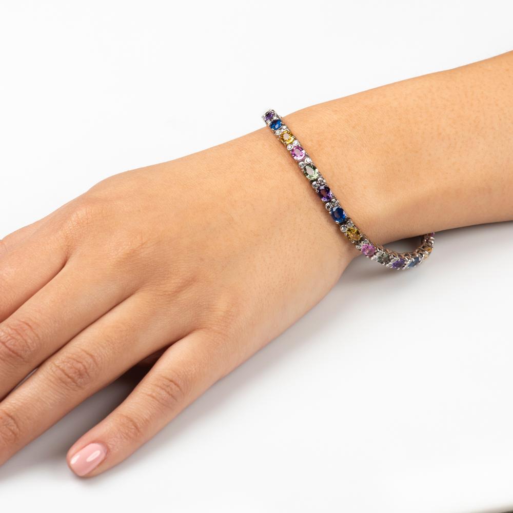 Beautiful multi colored natural sapphire bracelet with approximately 11.00 carats total weight in colored sapphires & approximately 0.75 carat total weight in fine round diamonds. Stones are all set in 14K white gold.