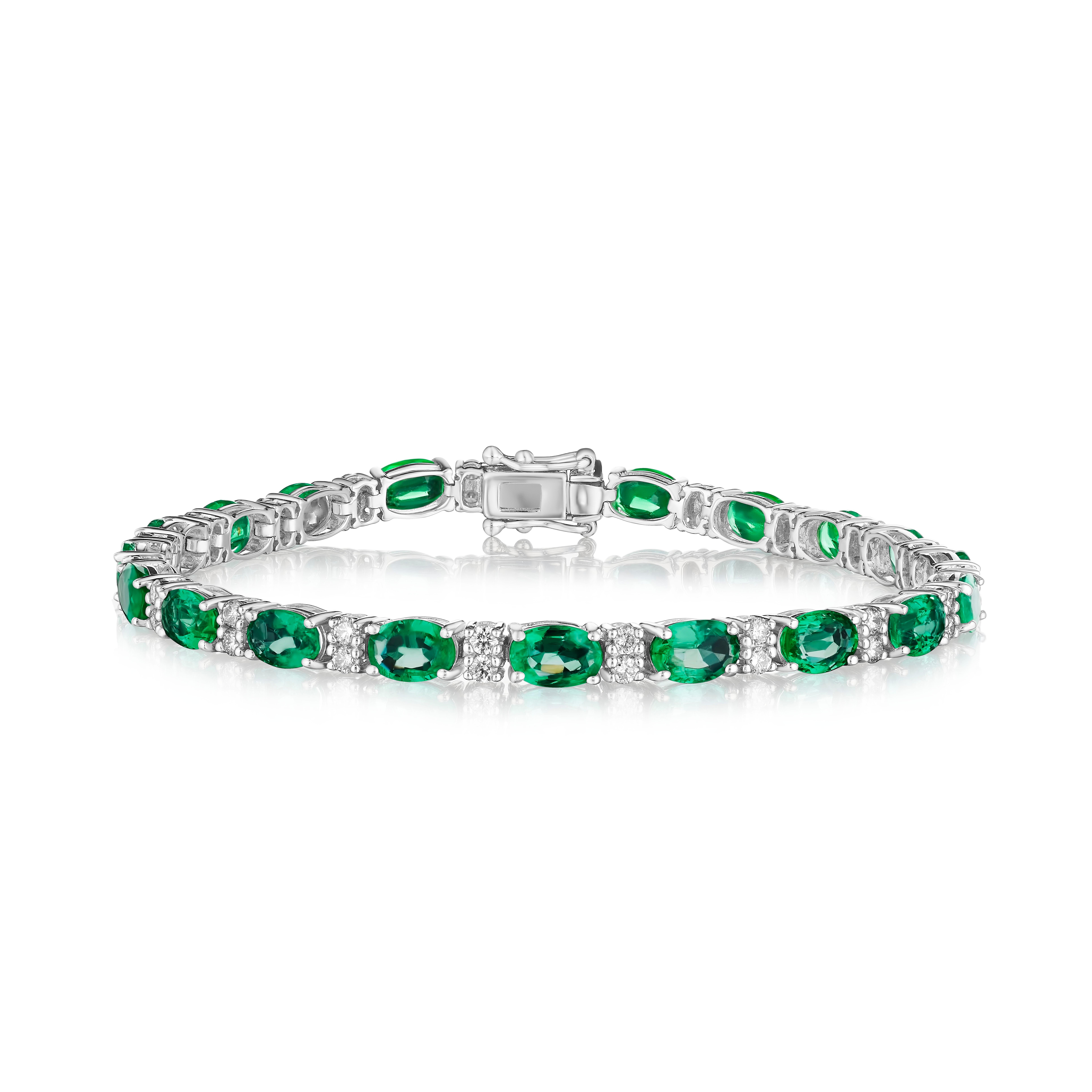 • A beautiful row of oval cut green emeralds and white round brilliant cut diamonds encircle the wrist in this bracelet, set in 14KT gold. The bracelet measures 7