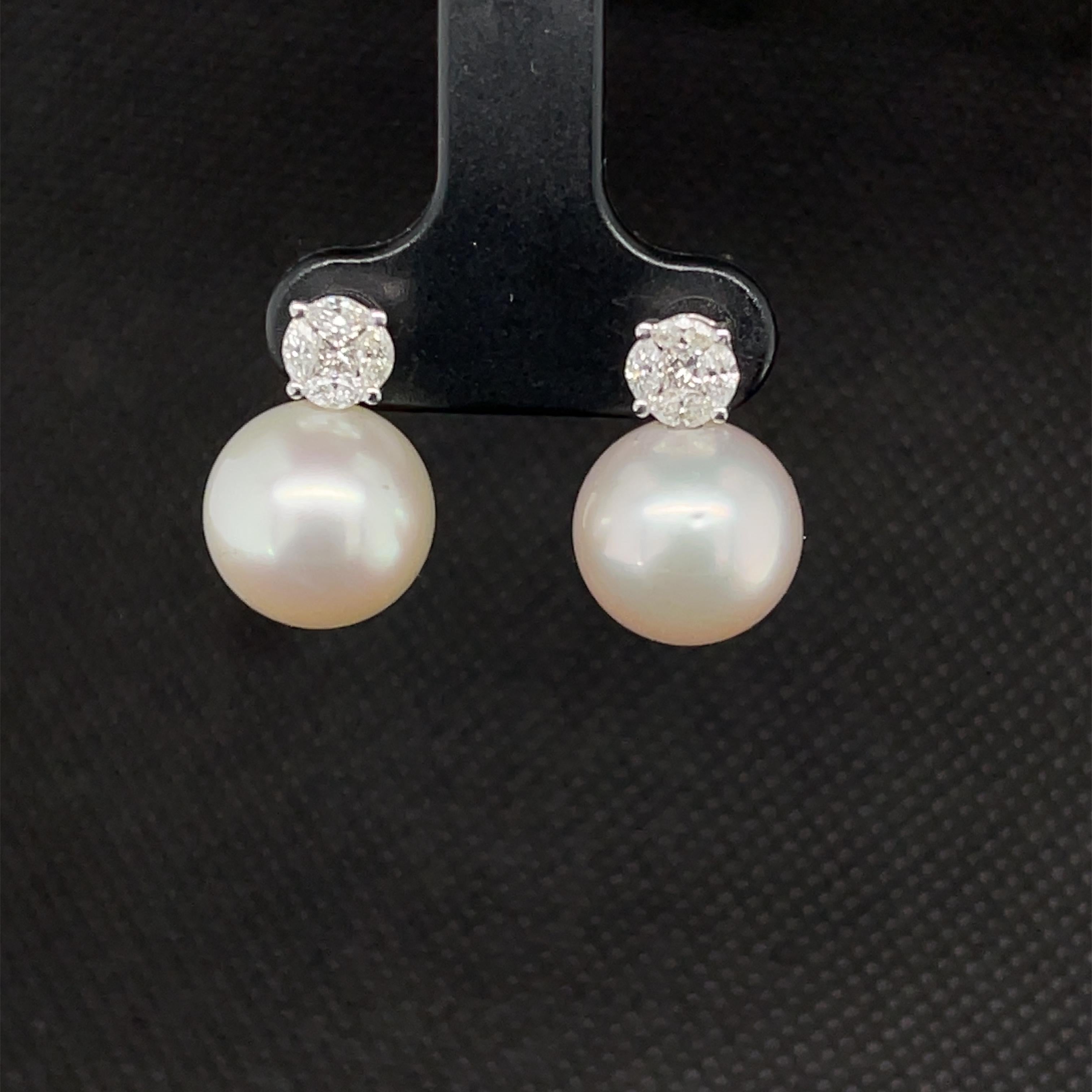 Set yourself apart with these gorgeous South Seas pearl and diamond drop earrings! These stunning earrings feature two large, 11mm, beautifully matched white South Seas pearls set in 18k white gold with princess and marquise-cut diamonds. Four