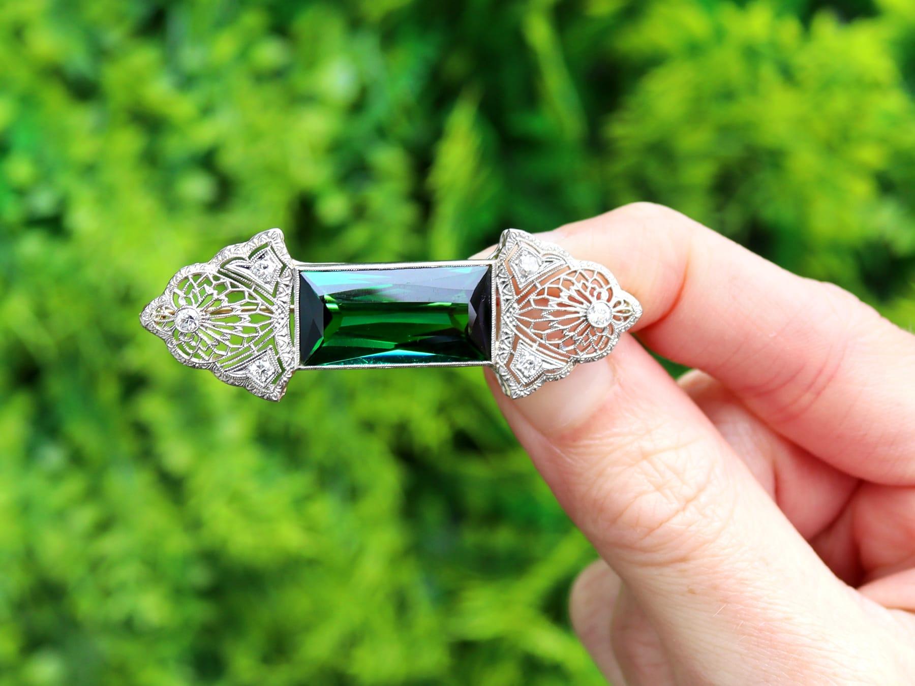 Una splendida, raffinata e imponente spilla antica degli anni '30 da 11,06 carati di tormalina verde e 0,18 carati di diamanti, incastonata in oro giallo 14k e platino; fa parte delle nostre diverse collezioni di gioielli antichi in
