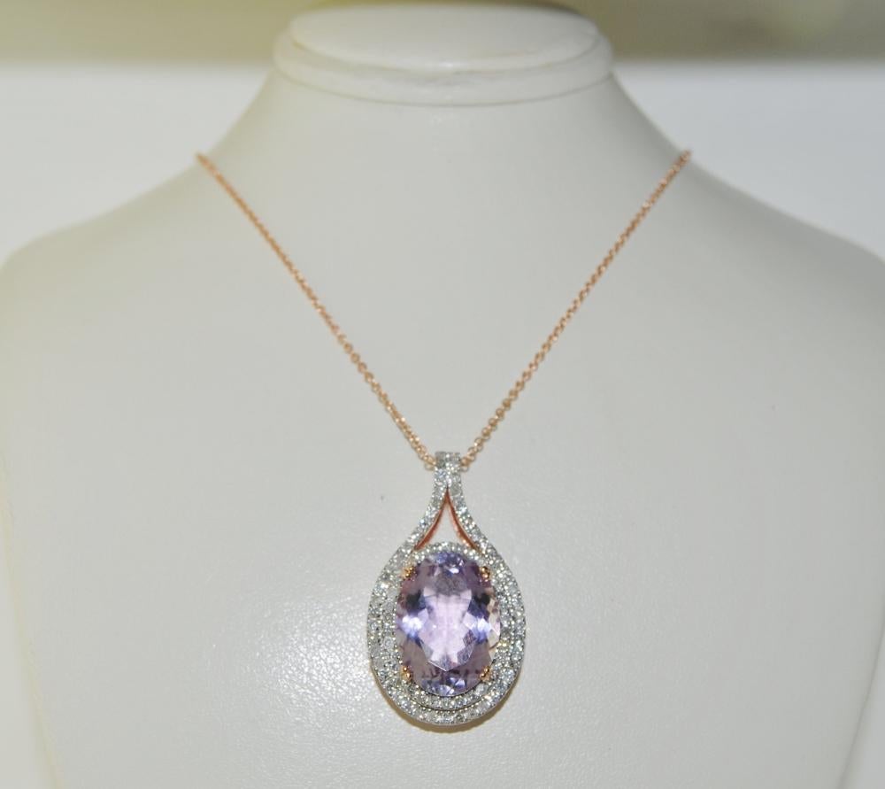 Pendant Necklace featuring 11.08 carat oval shape Amethyst surrounded by 1.12 carat brilliant round white Diamonds.  This pendant is mounted in 14K rose gold.  Length 1.25 inches, Width 0.75 inches.  Includes 18 inches chain.