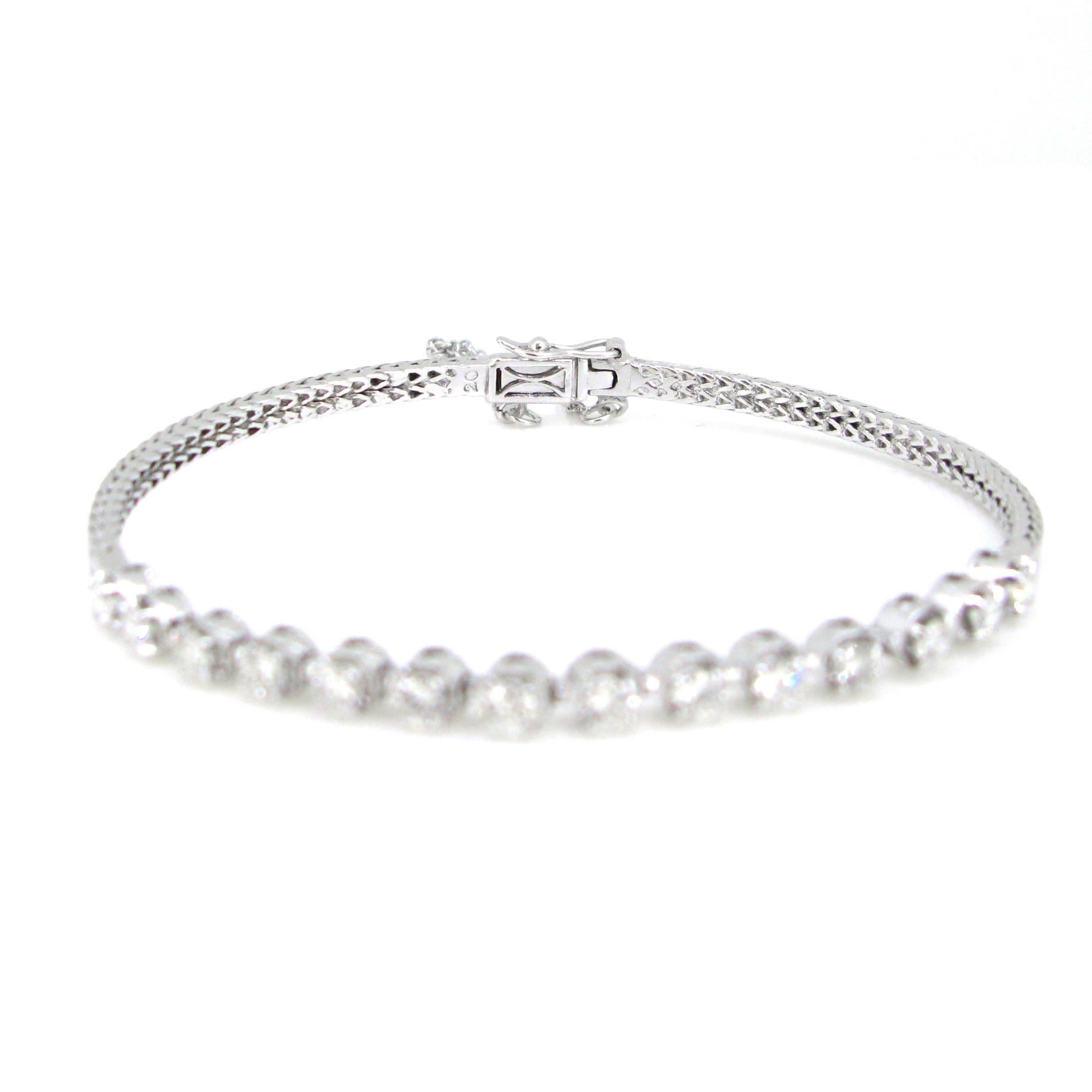 This elegant bracelet is semi rigid. It comprises a moving line set with 14 brilliant cut diamonds with a total carat weight of 1.10ct approximately. There are 2 bangles on each extremity of the lines. It closes firmly. It is secured with a clasp