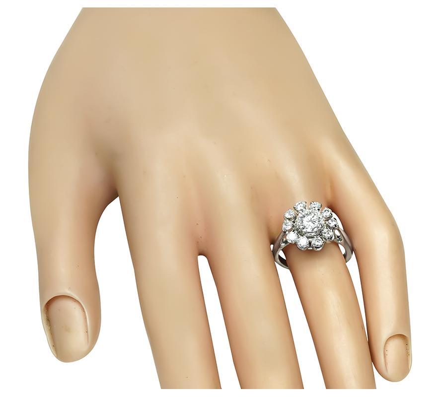 Questo è uno splendido anello in oro bianco 14k. L'anello è centrato da uno scintillante diamante a taglio rotondo del peso di circa 1.10 carati. Il colore del diamante è F con purezza SI2. Il diamante centrale è accentuato da splendidi diamanti a