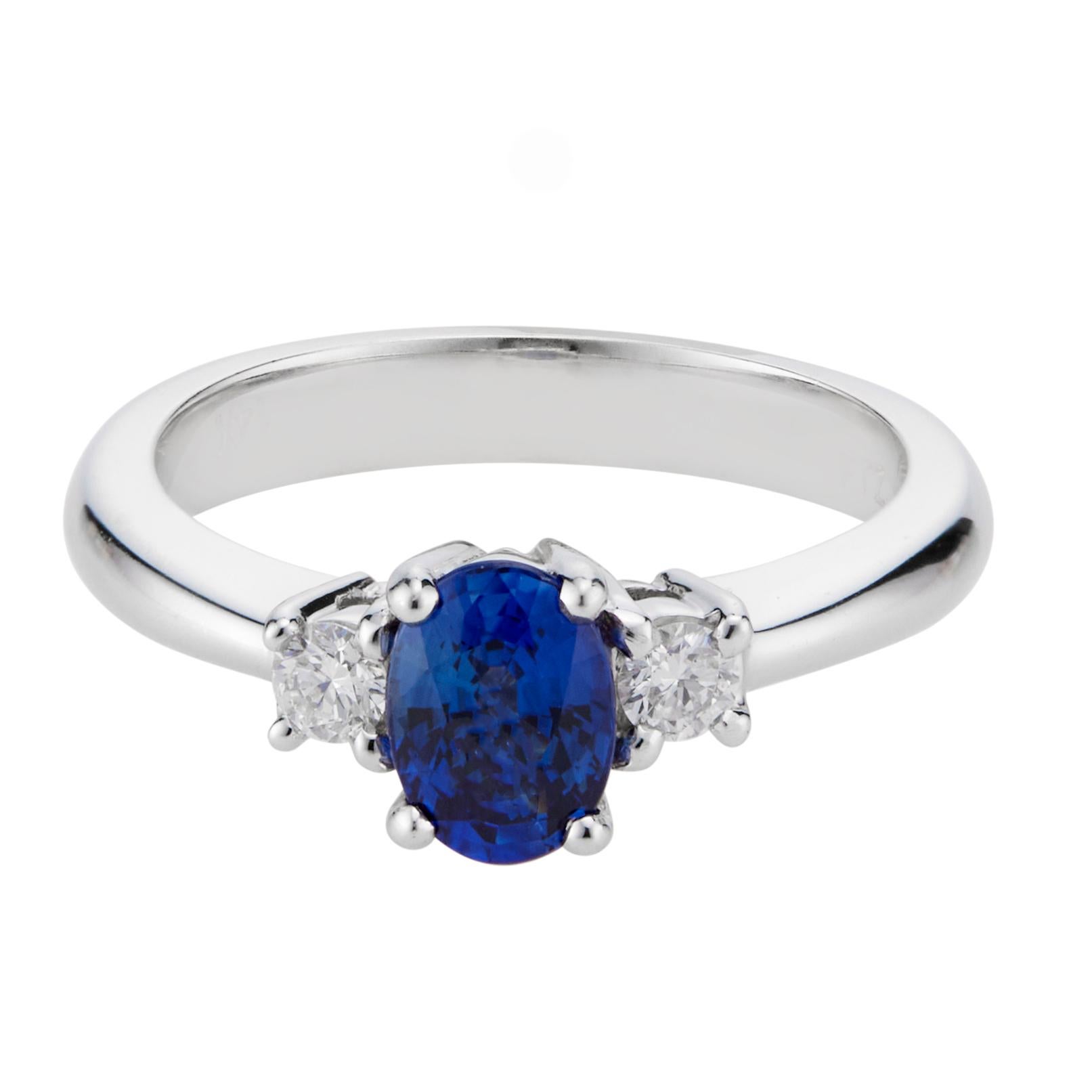 Ceylon Sapphire and diamond engagement ring. Oval sapphire center stone, simple low level heat only and no other enhancements. Set in a 14k white gold three-stone setting with 2 full cut side diamonds. 

1 oval Ceylon fine gem blue Sapphire, approx.