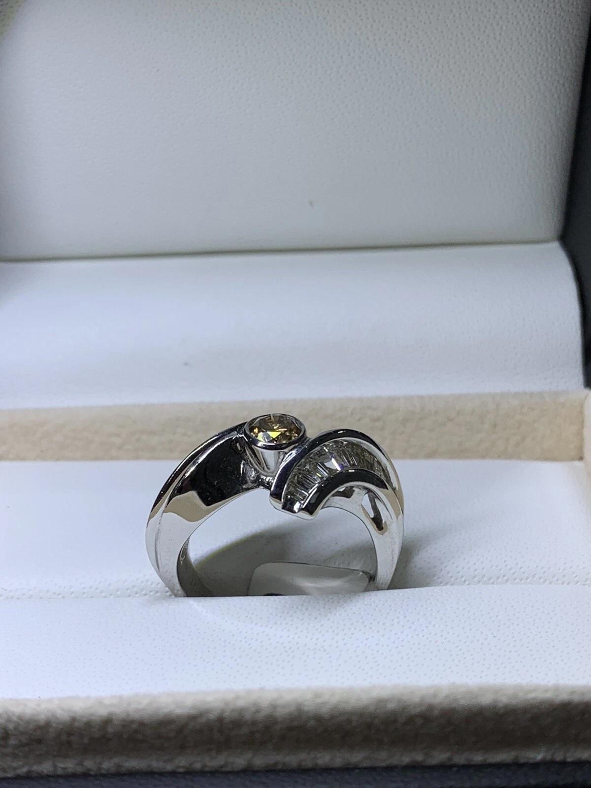 1.10ct Chocolate Brown Cognac diamond and baguette diamonds engagement ring in 18k gold.

Solitaire 1.10ct brown diamond round shaped with baguette diamonds twist style engagement ring in 18ct white gold.

Bezel setting in 18ct white gold.

Fancy