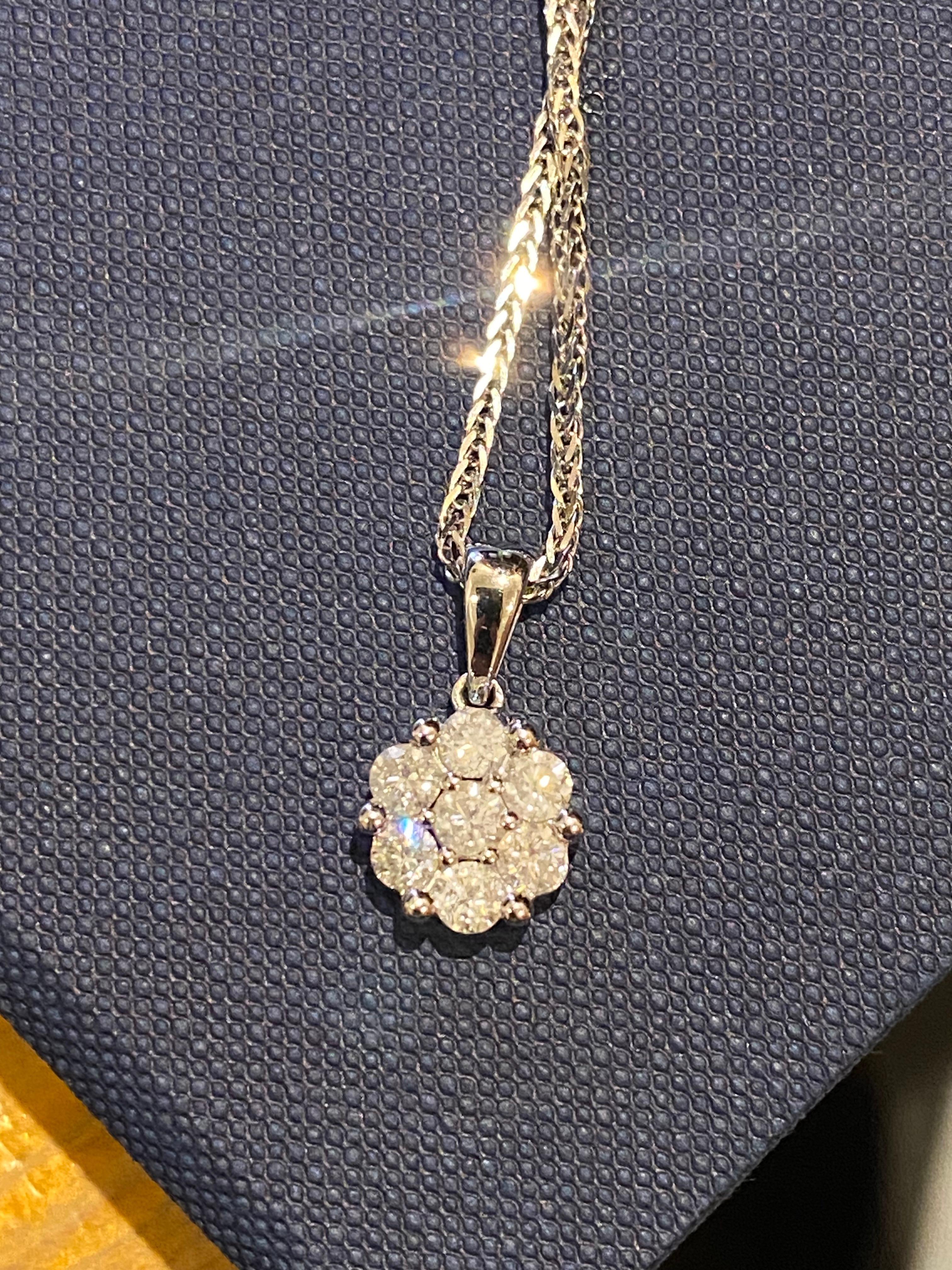 Designed as a flower / daisy 
pendant is set with 7 round brilliant cut diamonds 
totalling 1.10ct 
of H colour, SI clarity 
suspending from a solid bail, 
dimensions (including bail): 18mm x 9mm 

on a solid 18K white gold sturdy snake chain,