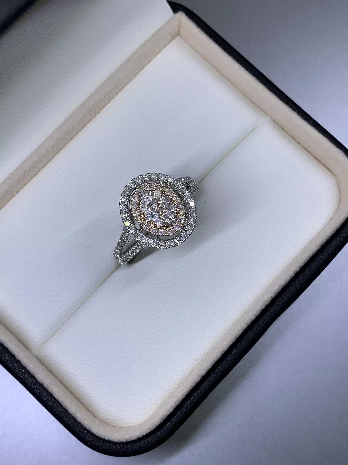 Cette exquise bague de fiançailles est ornée d'un superbe diamant naturel en guise de pièce maîtresse, parfaitement taillé en forme ronde pour rehausser sa brillance inégalée. Le diamant est serti dans un luxueux anneau en or blanc 18ct, rehaussé de