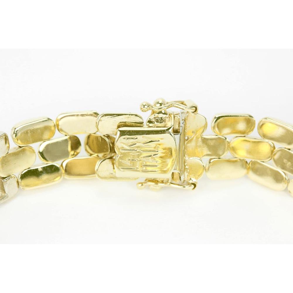 In mostra un bracciale con diamanti a maglie fantasia in oro giallo 14 carati. Questo bracciale presenta un'unica maglia dorata impreziosita da diamanti bianchi. Cento diamanti completamente sfaccettati danzano sotto qualsiasi luce, mostrando