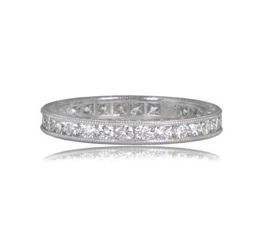 This exquisite platinum wedding band boasts a width of 3mm and features a dazzling display of 1.10 carats of channel-set diamonds. The sides are adorned with enchanting scroll-motif engravings, adding a touch of romance to this timeless piece.

Ring