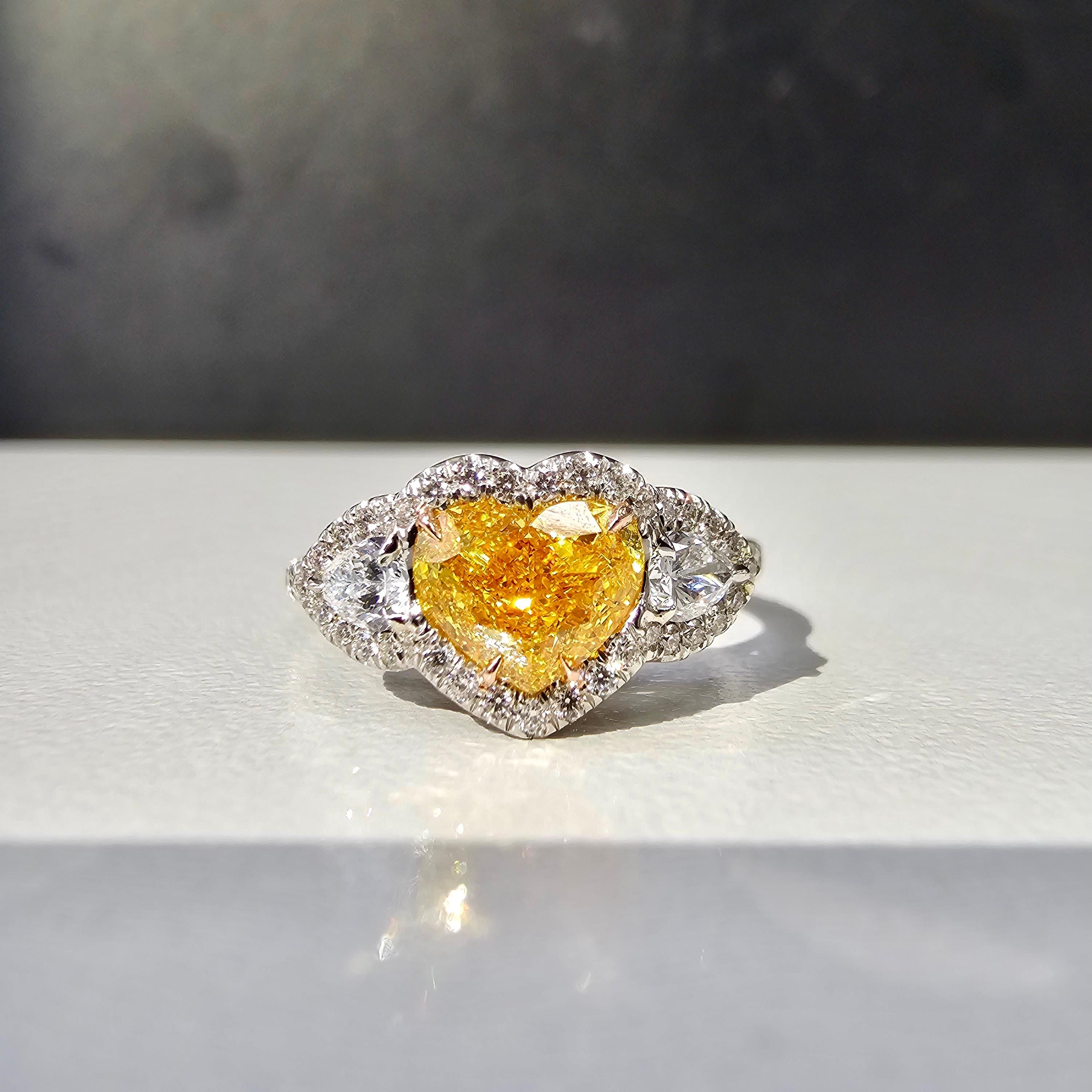 Rare and beautiful 1ct Fancy Vivid Orange Yellow Heart with VS clarity. The diamond faces up completely orange!
This diamond is absolutely on fire with no bow tie, but pure scintillation throughout the stone
Handmade Platinum ring with 0.29ct of