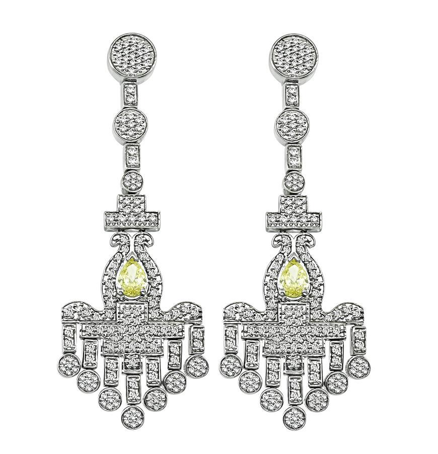 This is a gorgeous pair of 18k white gold chandelier earrings. The earrings feature sparkling pear shape fancy yellow diamonds that weigh approximately 1.10ct. The clarity of the diamonds is SI1. The fancy yellow diamonds are accentuated by dazzling