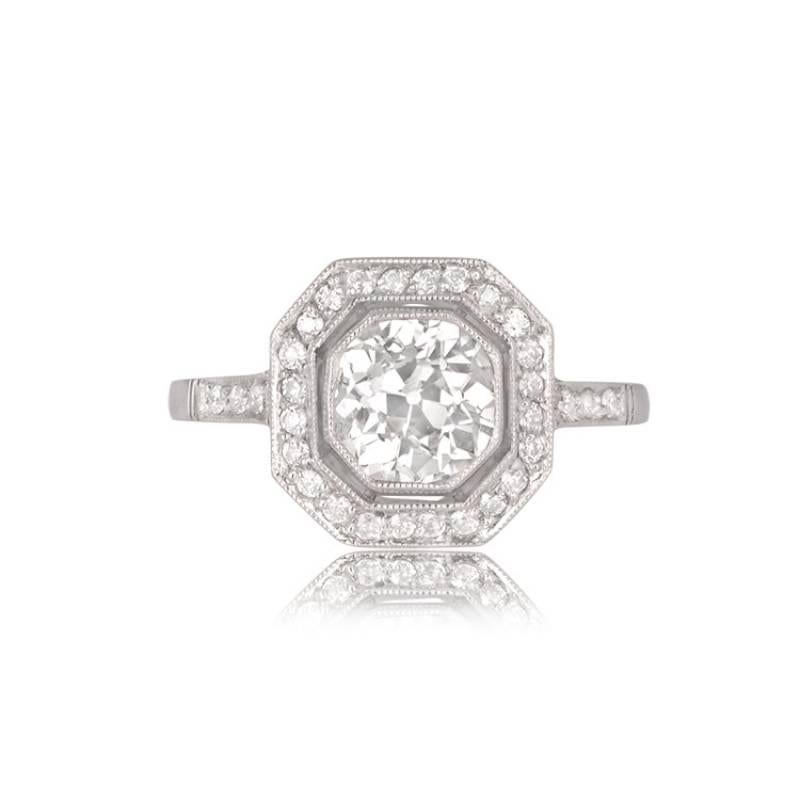 A geometric halo engagement ring showcases a central old European cut diamond, approximately 1.10 carats. The center diamond boasts J color and VS1 clarity, captivating with its brilliance. Encircling the centerpiece is an octagonal halo of old