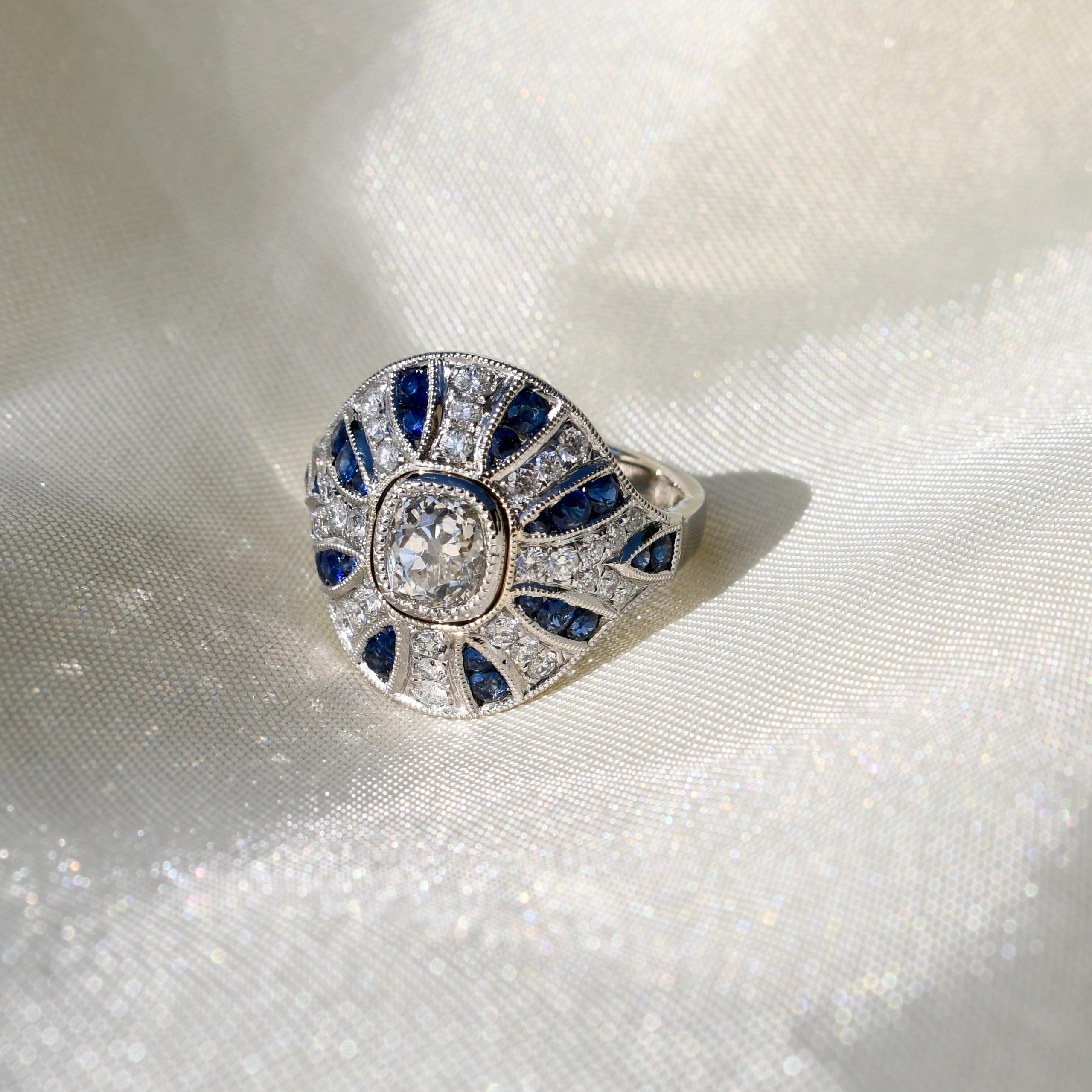 This ring was newly made and is in excellent condition. 

- One GIA certified old mine cut diamond, 1.10 ct (J/ SI1) 
- Thirty four brilliant cut diamonds, 0.56 ct total 
- Twenty eight sapphires, 0.99 ct total 
- Total diamond weight: 1.66 ct
-