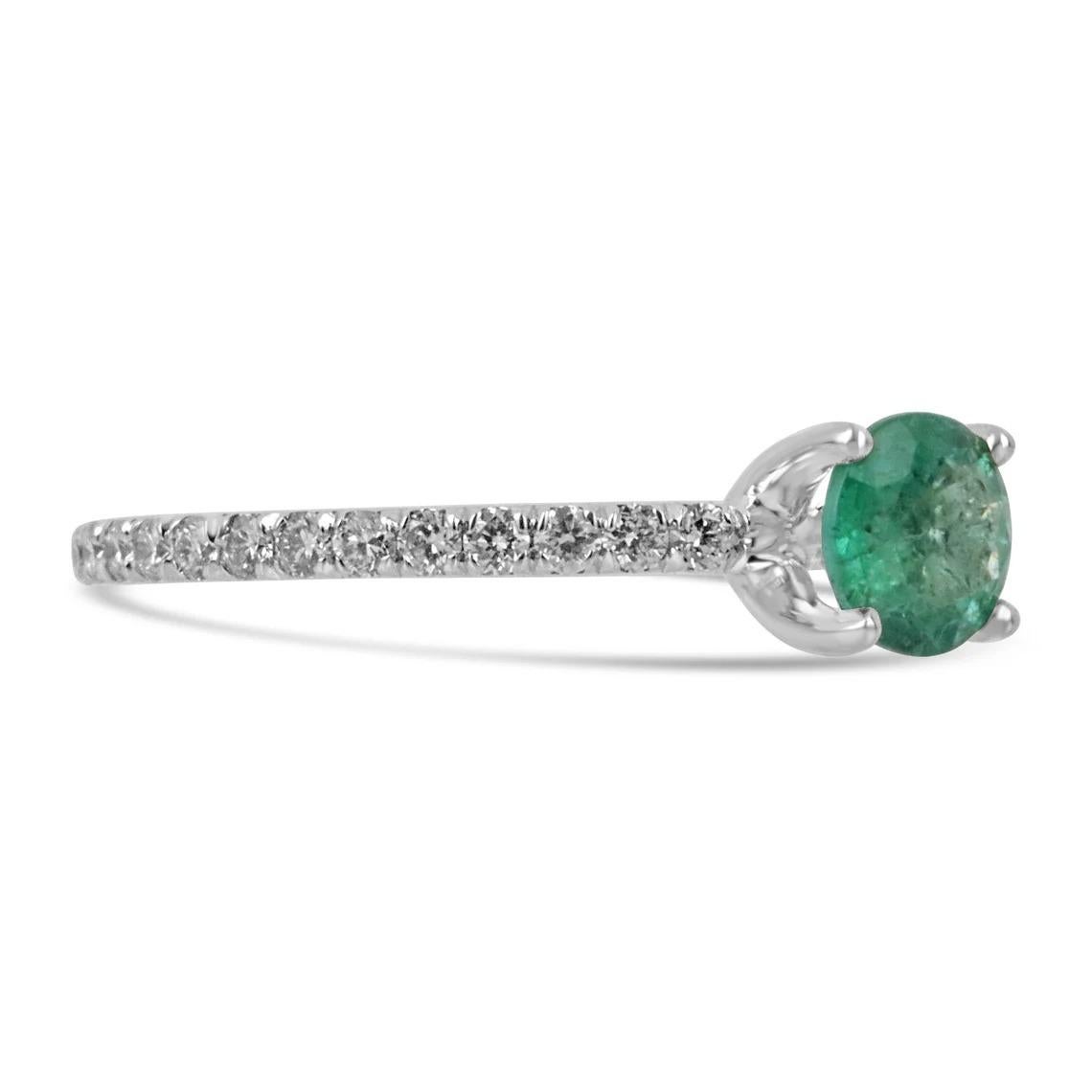 Elegantly displayed is a natural round-cut emerald and diamond ring. The center gem is a beautiful quality, round cut, emerald filled with life and brilliance! Among the emeralds, impressive qualities are their vibrant color and beautiful eye