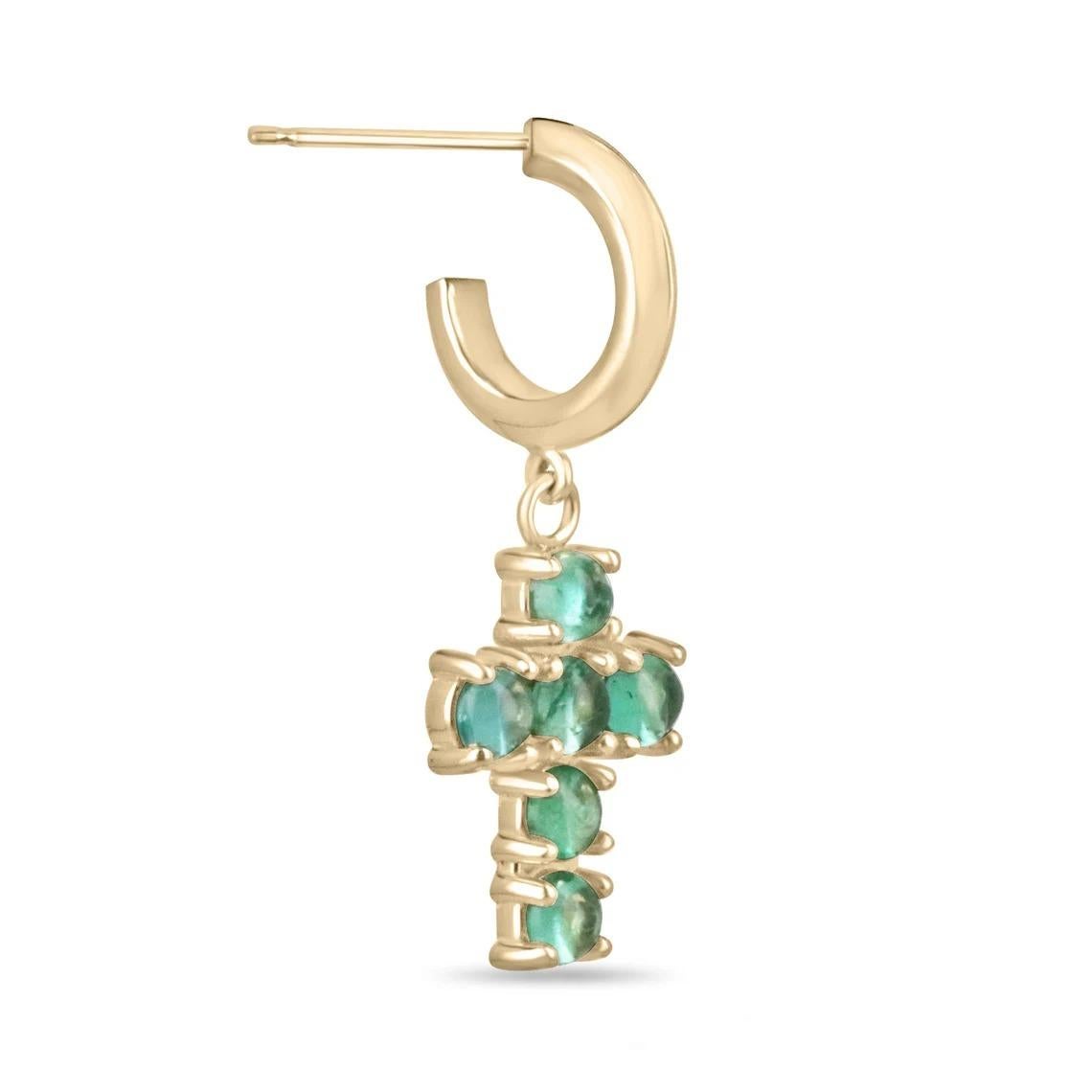 These emerald dangle cross earrings showcase stunning medium light green round cut cabochon emeralds. The emeralds are beautifully set in a cross-shaped setting, securely held in place by prongs. Crafted in 14k gold, these earrings combine elegance