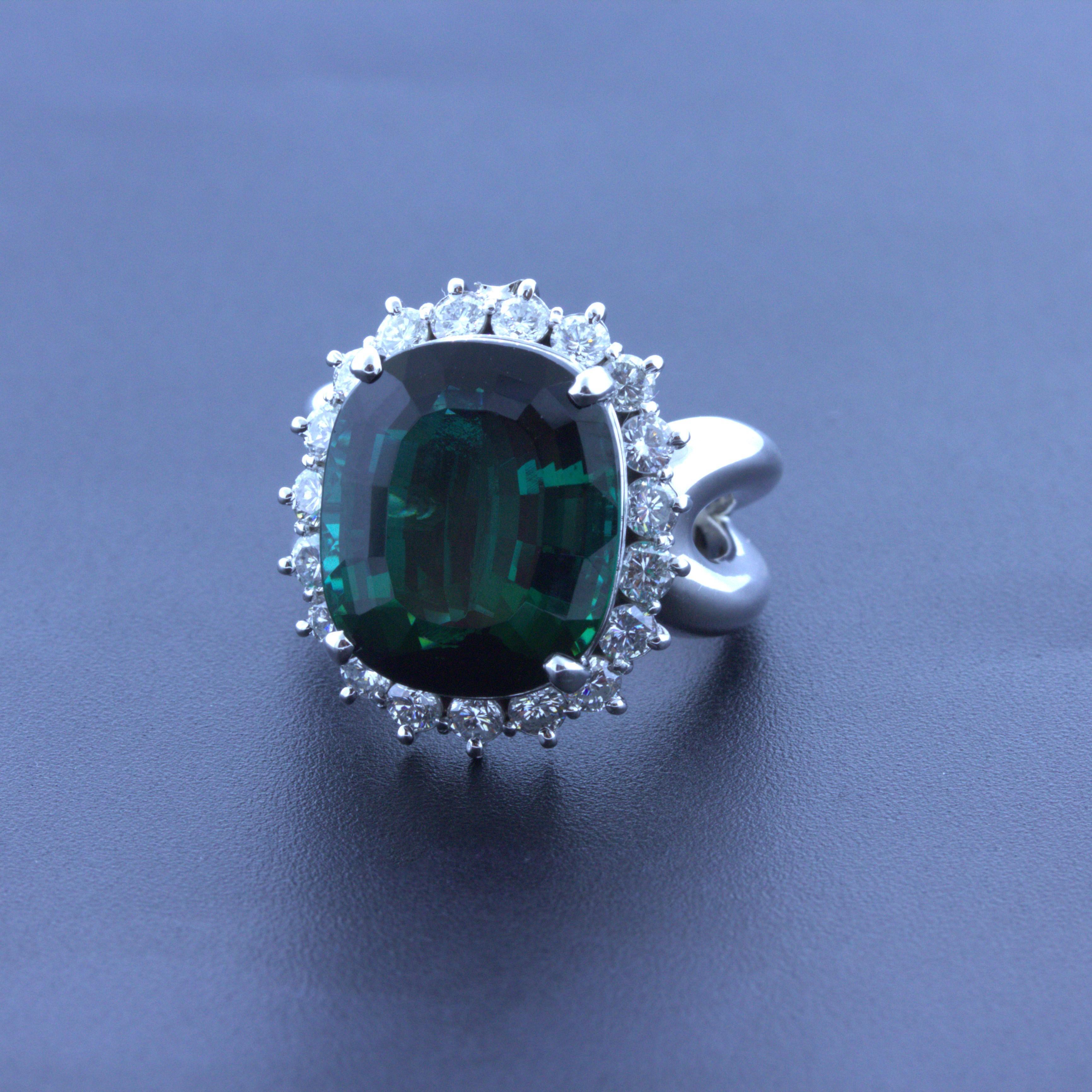 A classic diamond halo gemstone ring featuring a very fine green tourmaline. It weighs a substantial 11.10 carats and has a rich velvety green color with a hint of blue. The color reminds us of indicolite tourmaline if green was a color variety of