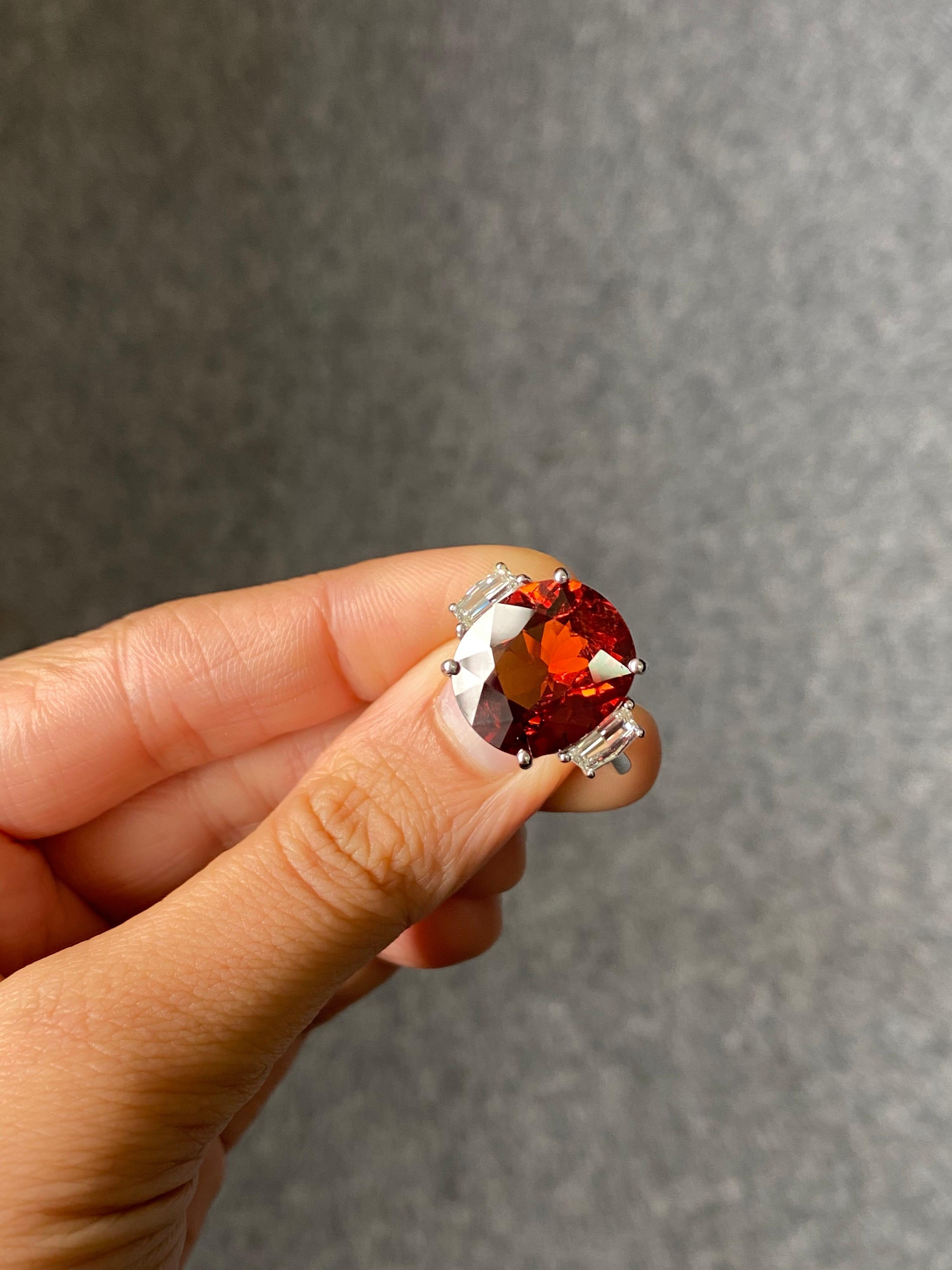 Un grenat mandarin unique de 11,11 carats, absolument transparent, sans inclusions et d'un bel éclat, et un diamant blanc de 0,56 carat, taille Cadillac, qualité VS, pierre latérale, bague de fiançailles à trois pierres. Cette superbe bague est