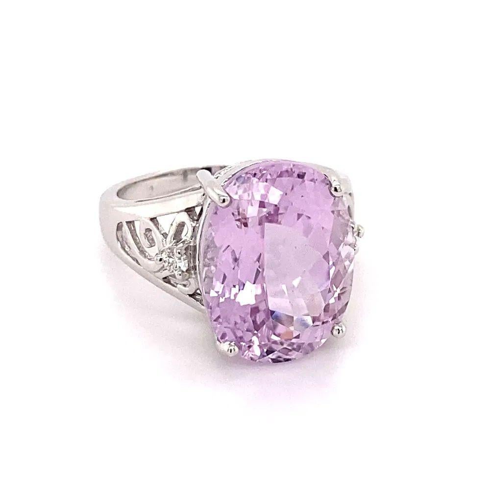 Simply Beautiful! Finely detailed Oval Kunzite and Diamond Gold Ring. Featuring a securely Hand set 11.19 Carat Oval Kunzite. Accented either side by Diamonds, weighing approx. 0.09tcw. Hand crafted 18K White Gold mounting. Size 7, we offer ring