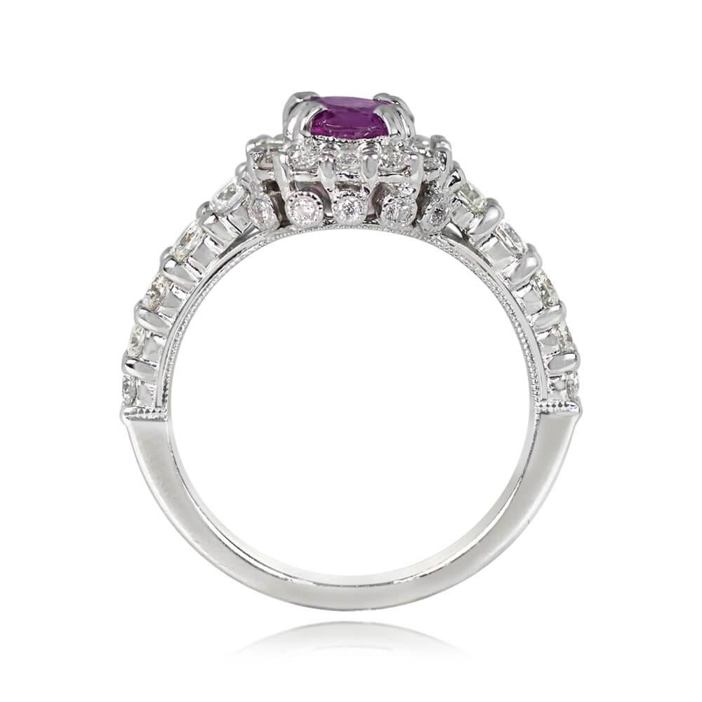 A captivating pink sapphire and diamond halo ring showcases a 1.11-carat cushion-cut pink sapphire, pristinely set. Round brilliant cut diamonds encircle the central gemstone and adorn half of the shank. The under-gallery is adorned with small round