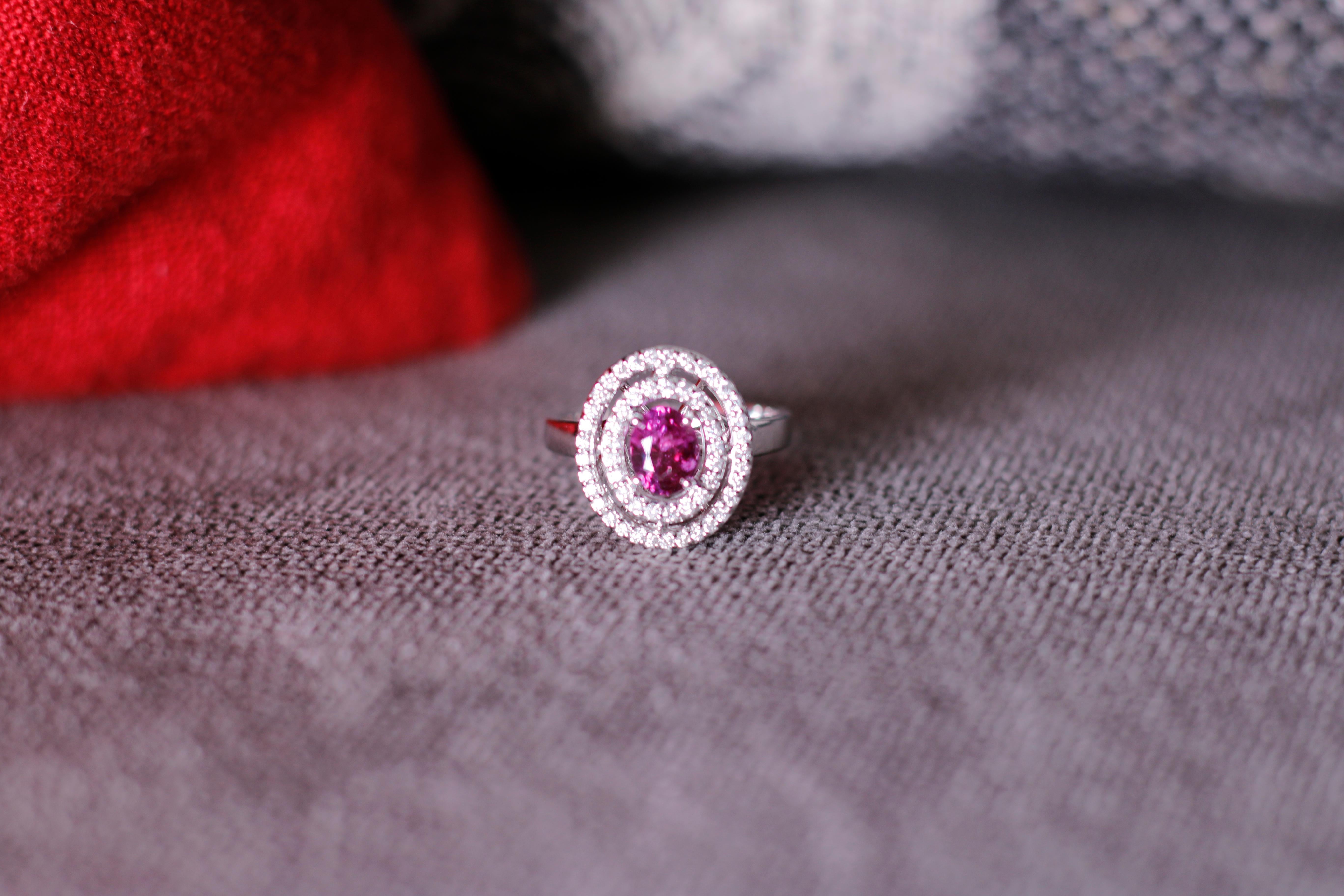 Crafted with a high luster Pink Sapphire stone (1.12ct) from Sri Lanka, this is a one of kind ring that can truly make a statement. Ring is made with 18 karat white gold and Si diamonds. Diamonds are added as a double cluster to give a truly