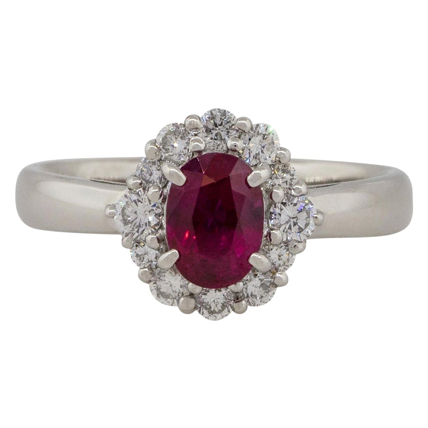 Anello aureolato con rubino ovale e diamante centrale da 1,12 carati in platino in stock