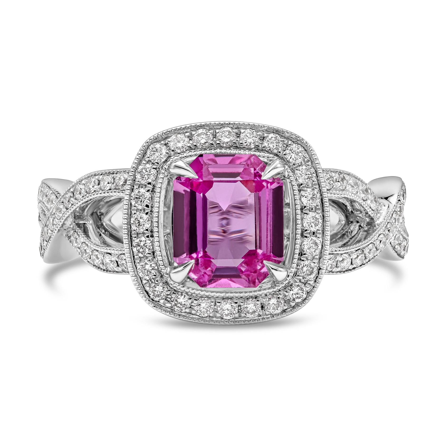 A unique gemstone engagement ring style showcasing an emerald cut pink sapphire center stone weighing 1.12 carat total, set in a classic four prong cushion shape box.  Surrounded and accented by round melee diamonds in a halo design and accenting