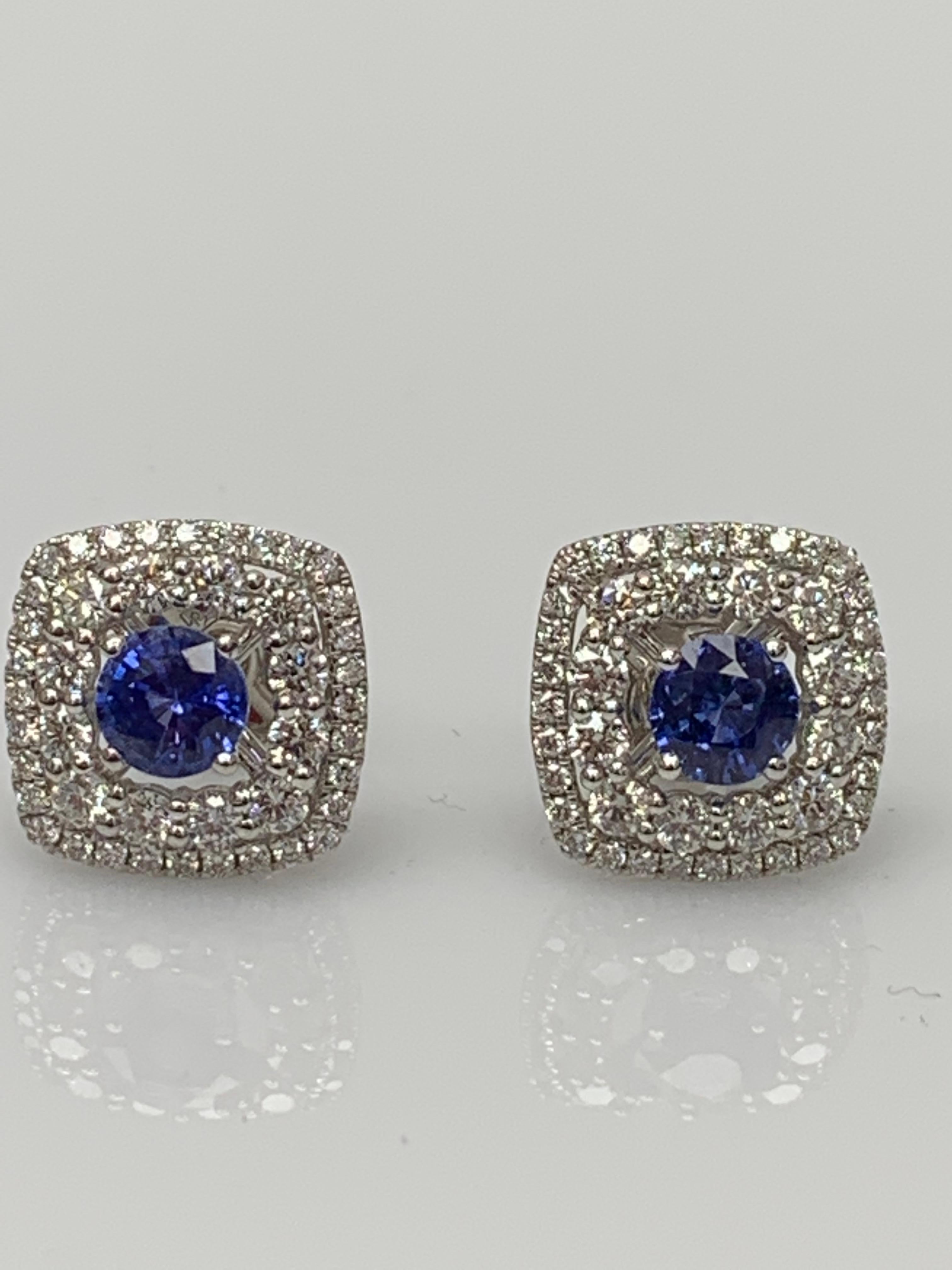 Un sencillo par de pendientes de botón con 1,12 quilates de zafiros azules redondos 2, rodeados por una doble fila de 88 diamantes redondos brillantes de 1,12 quilates de peso y fabricados en oro blanco de 18 quilates.