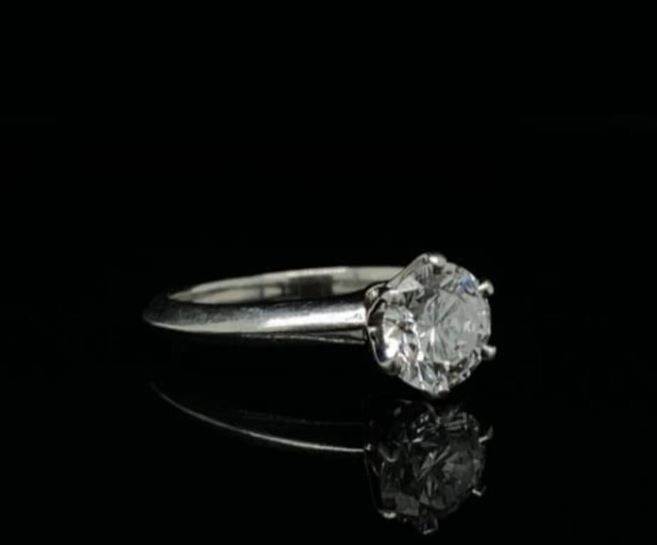 A 1.12 carat Tiffany & Co platinum round brilliant cut diamond engagement ring.

The round brilliant cut diamond is estimated by us as D colour and VS1 clarity.

This classic iconic 'Setting' solitaire ring designed by Tiffany & Co is set within six