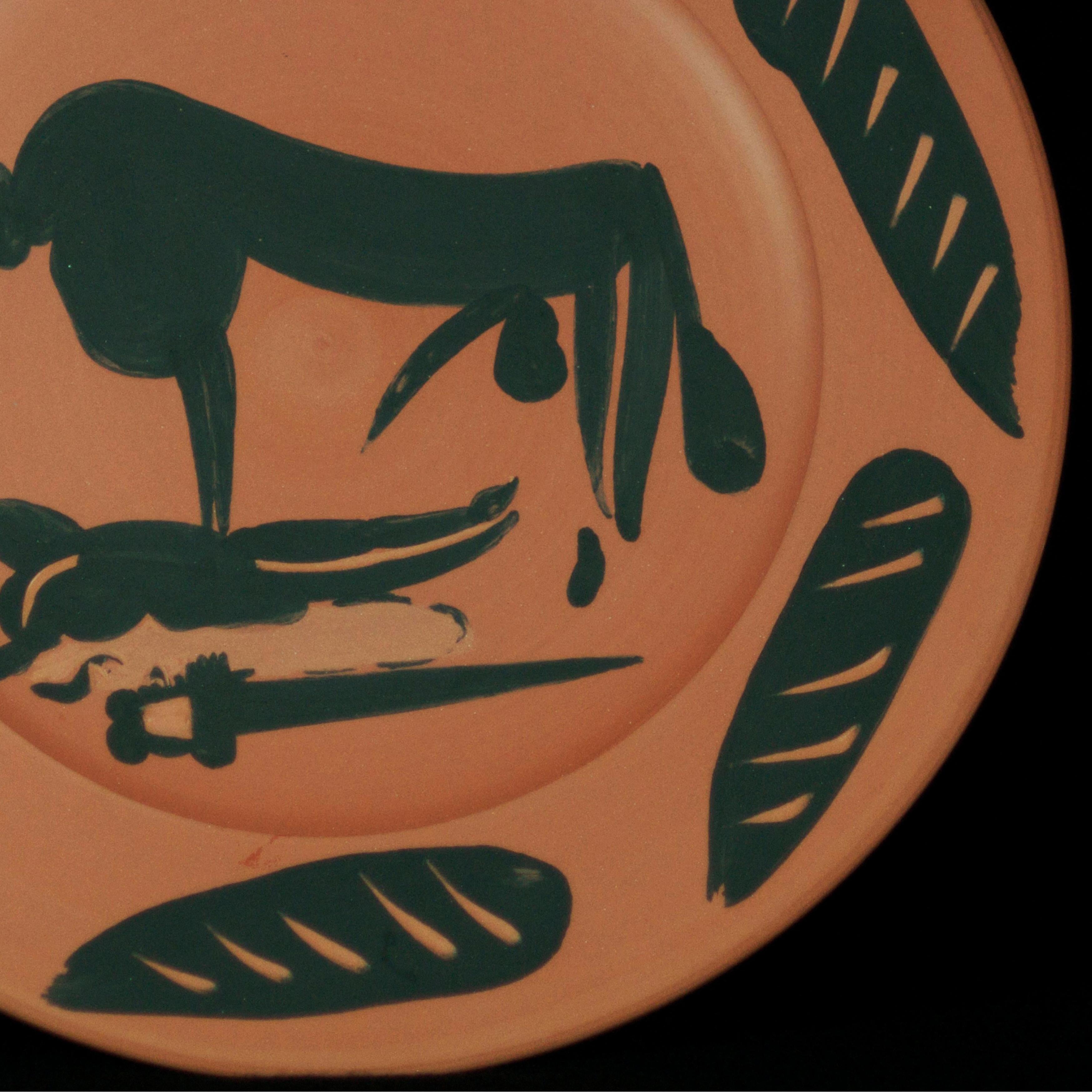 This piece is an A.R. turned round plate by Pablo Picasso made in 1957. It is made with red earthenware clay, engobe decoration, and knife engraved in black. It is from the edition of 500 and measures 9 inches in diameter. It is referenced as number