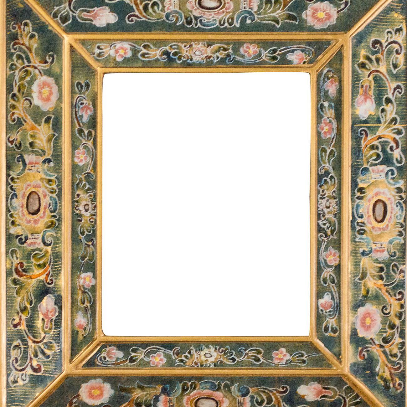 This colorful glass frame, now being repurposed as a mirror, was hand painted by an unknown Peruvian artist. The opening of the frame is 8 inches high by 10 inches wide and makes a gorgeous piece of décor; the perfect heirloom worthy giftable for