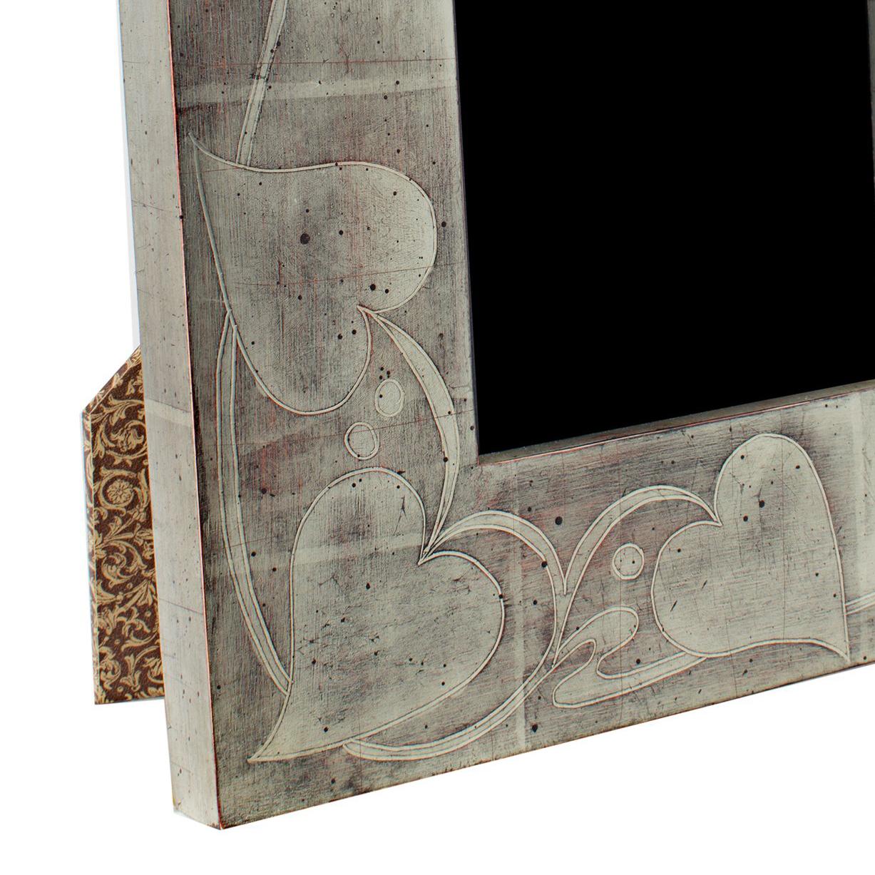 This photo frame was hand-made in Romania and features 12K white gold leafing. It is made out of wood and includes archival plexiglass to protect anything displayed in it from fading or other damage from light. This frame can be used both vertically