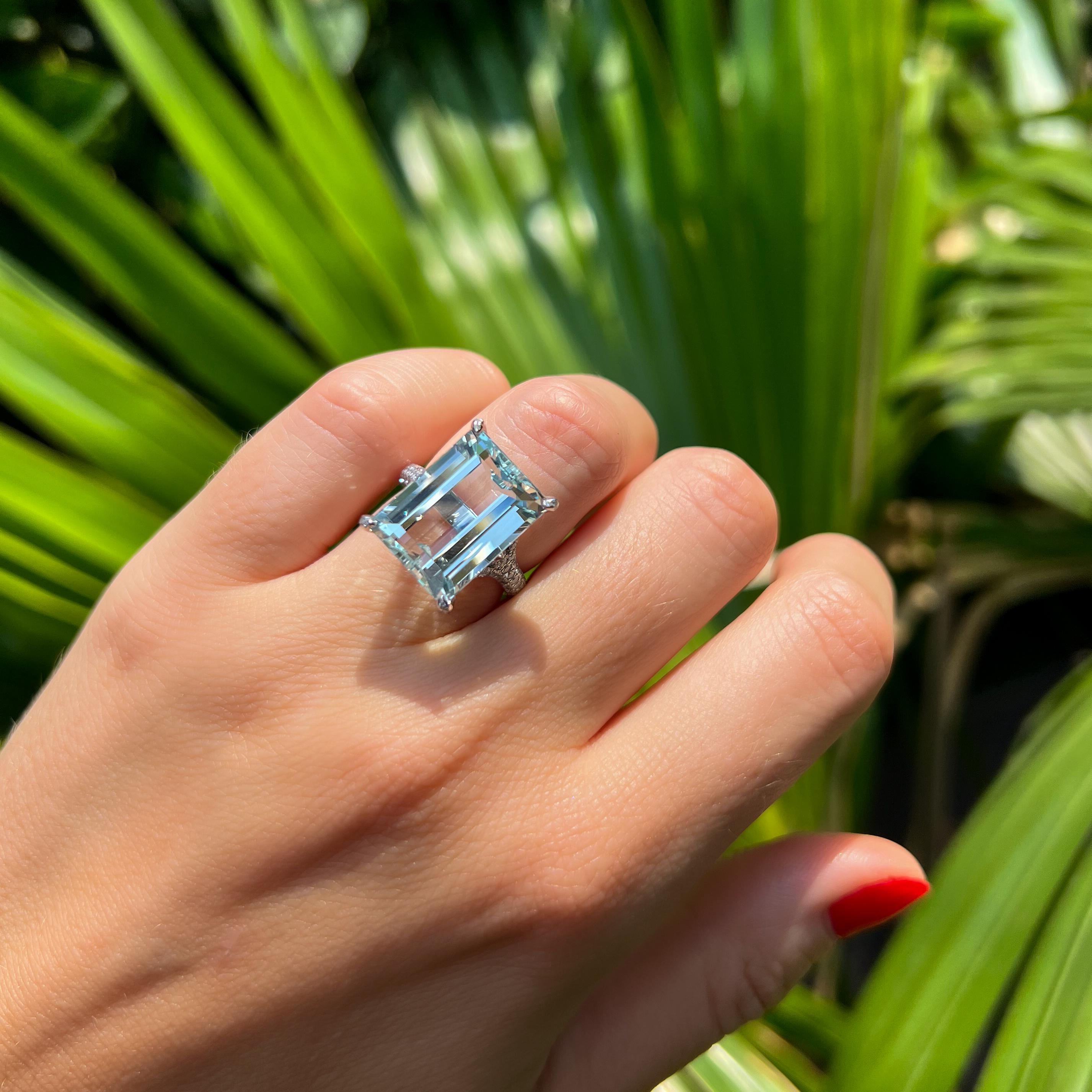Stunning, clear and perfectly cut pale blue 11.23ct Aquamarine, set in a Diamond micropave ring. The clean emerald-cut facets reflect the light perfectly whether you are inside or outside. 

The 6 claws are fully encrusted in dazzling diamonds,