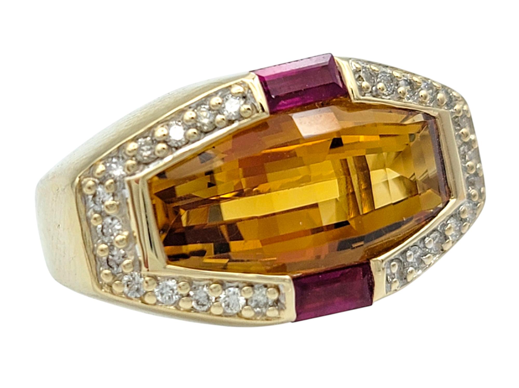 Ring Size: 5
 
A bold expression of color and craftsmanship, this striking ring showcases a mesmerizing designer-cut citrine at its center, radiating warm orange hues. Framed by rich red baguette-cut rubies, the geometric composition creates a