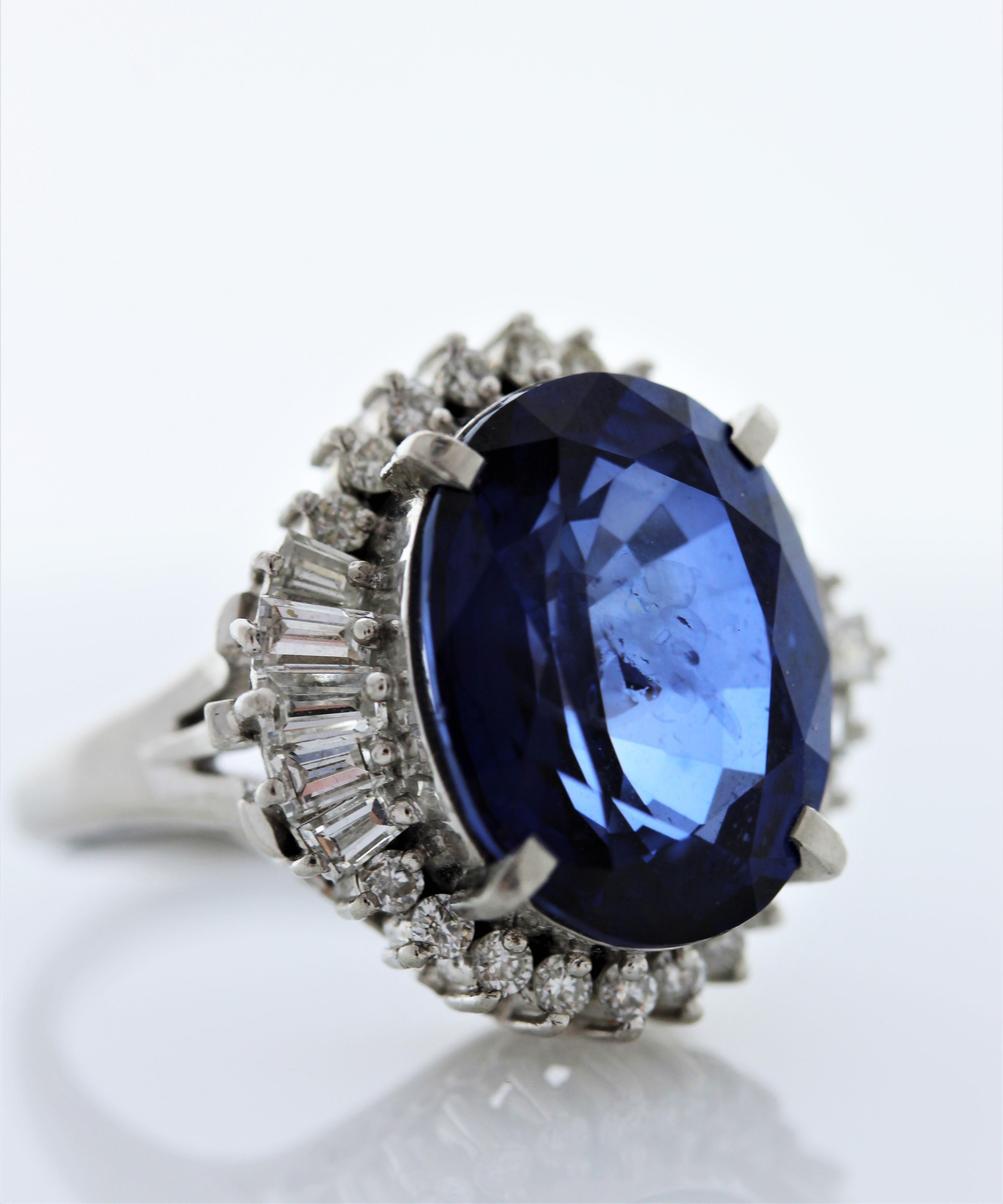 Introducing a truly magnificent creation that epitomizes luxury and sophistication: our exceptional 11.24 carat certified Oval Blue Sapphire Ring adorned with 28 Diamonds totaling 1.04 carats, meticulously set in exquisite Platinum. At the heart of