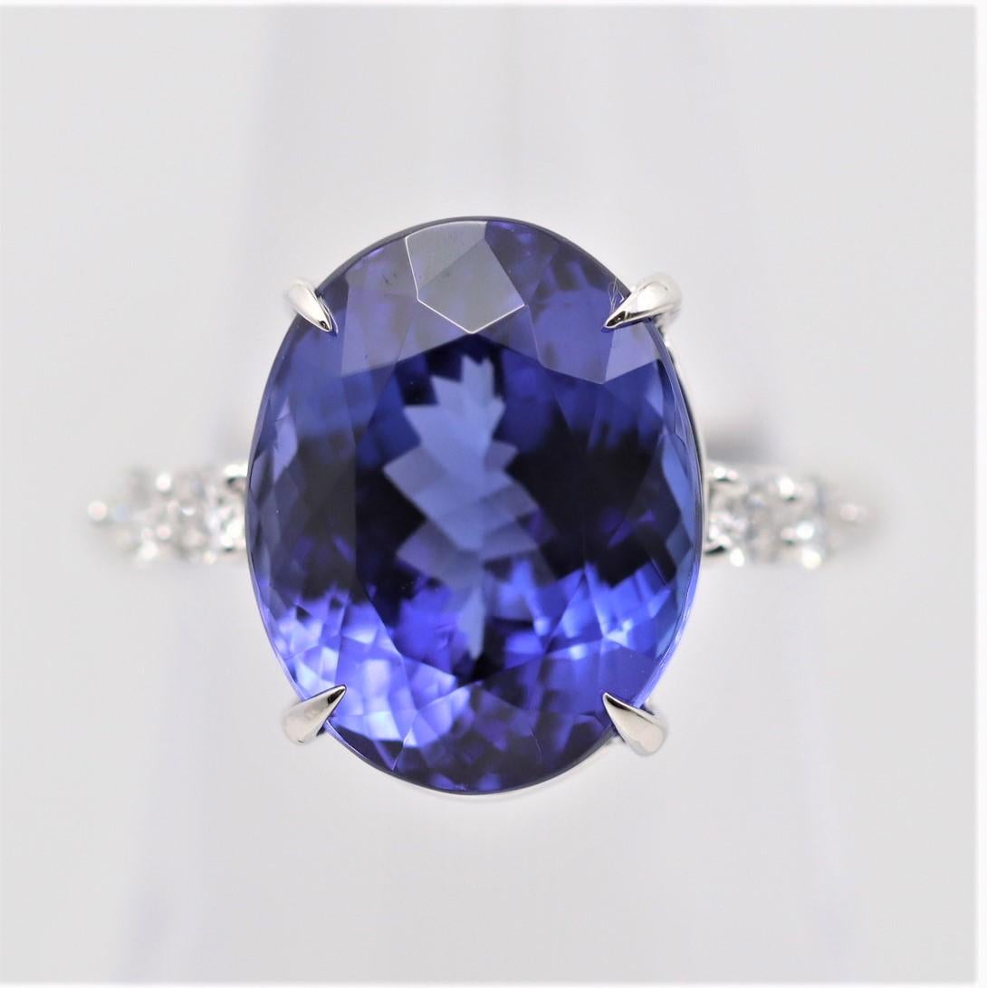 A large and fine gem-quality tanzanite weighing 11.25 carats takes center stage! It has a lovely oval shape with a bright, brilliant, and vivid purple-blue color that will make you smile. It is accented by 4 round brilliant-cut diamonds set on its