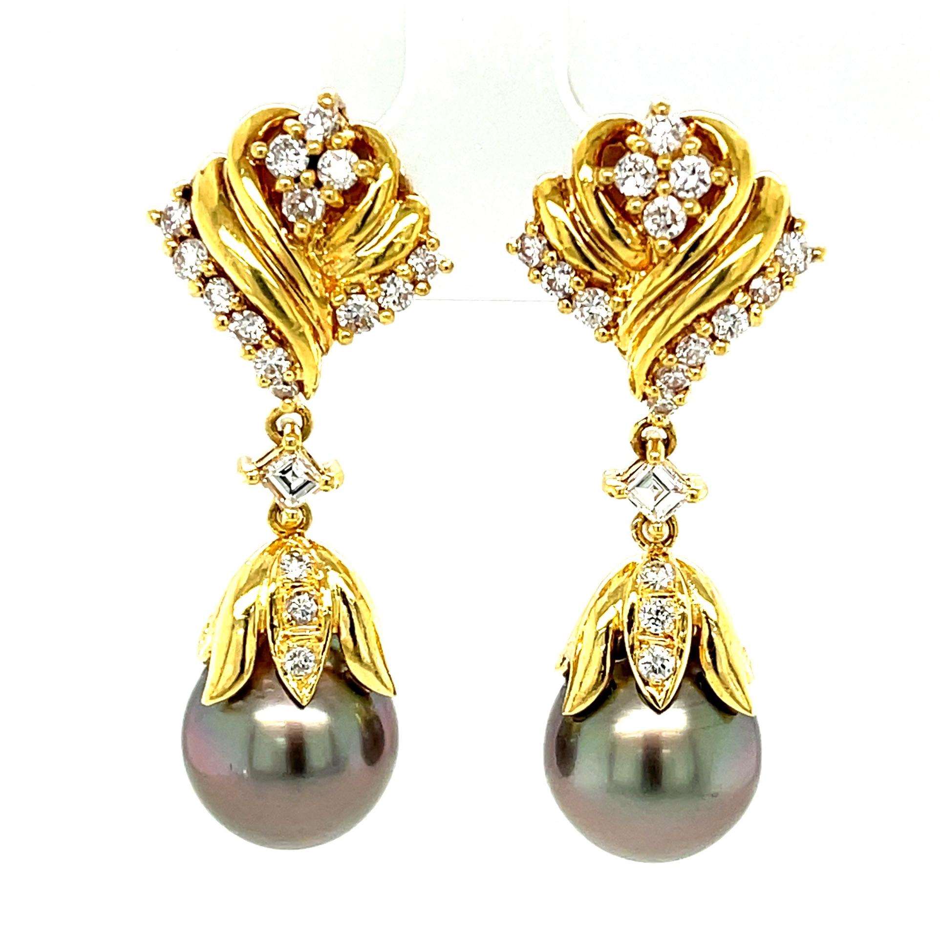 Large and lustrous 11.25mm South Sea pearls set with diamonds are featured in these gorgeous 18k yellow gold dangle earrings. The silver-grey pearls are accented beautifully by round and square cut diamonds weighing a total of 1.34 carats. These