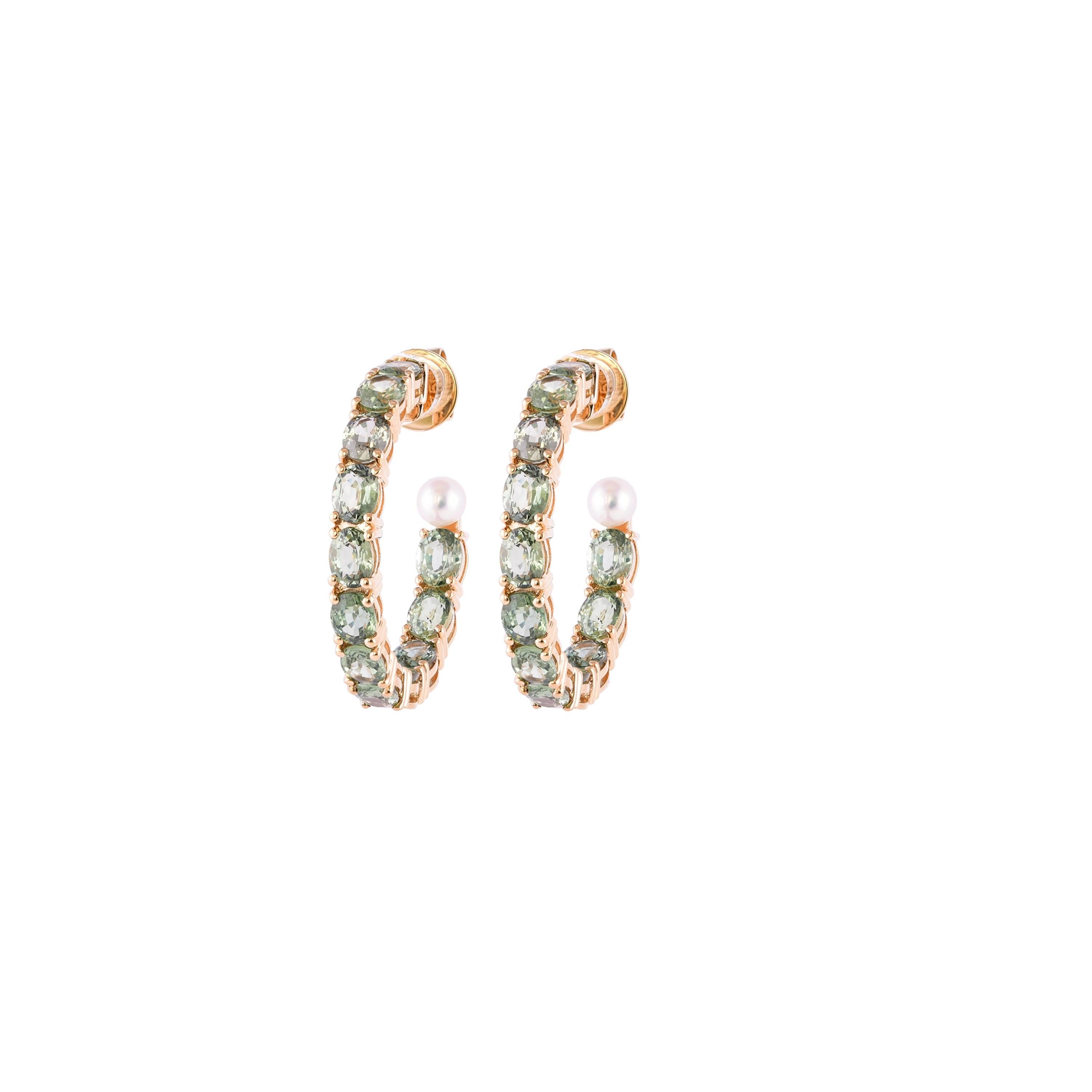 Sunita Nahata presents a collection of simple, classic and dainty sapphire earrings. These earrings in particular feature sparkling green sapphire hoops with elegant pearls to accent the gemstones. These are light and comfortable and are suitable