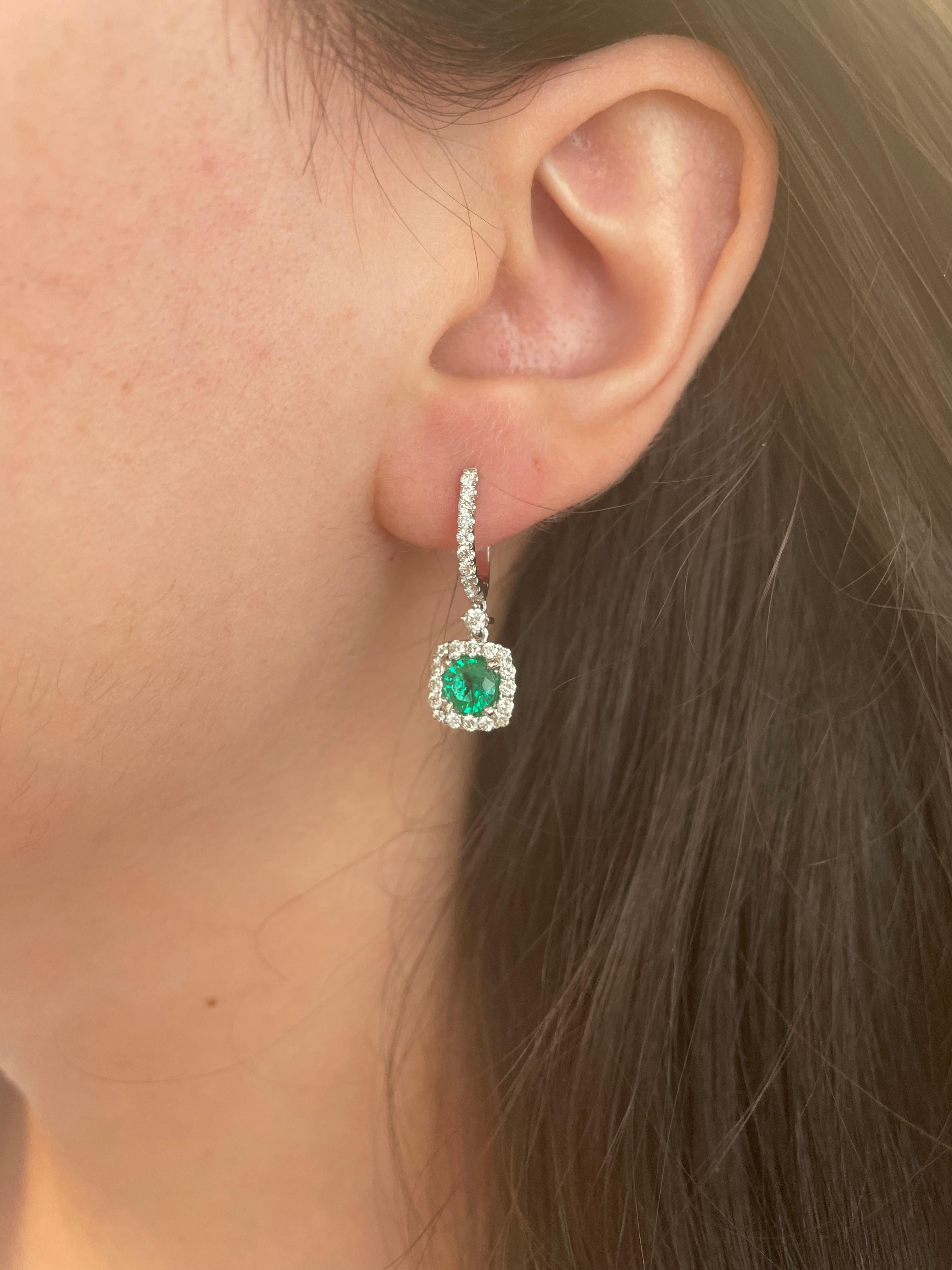 Sensational emerald and diamond drop earrings.
2 round emeralds, 1.12 carats total. Complimented by 54 round brilliant diamonds, 0.82 carats. Approximately G/H color and SI clarity. 18k white gold, 5.30 grams. 
1.94ct total gemstone weight.