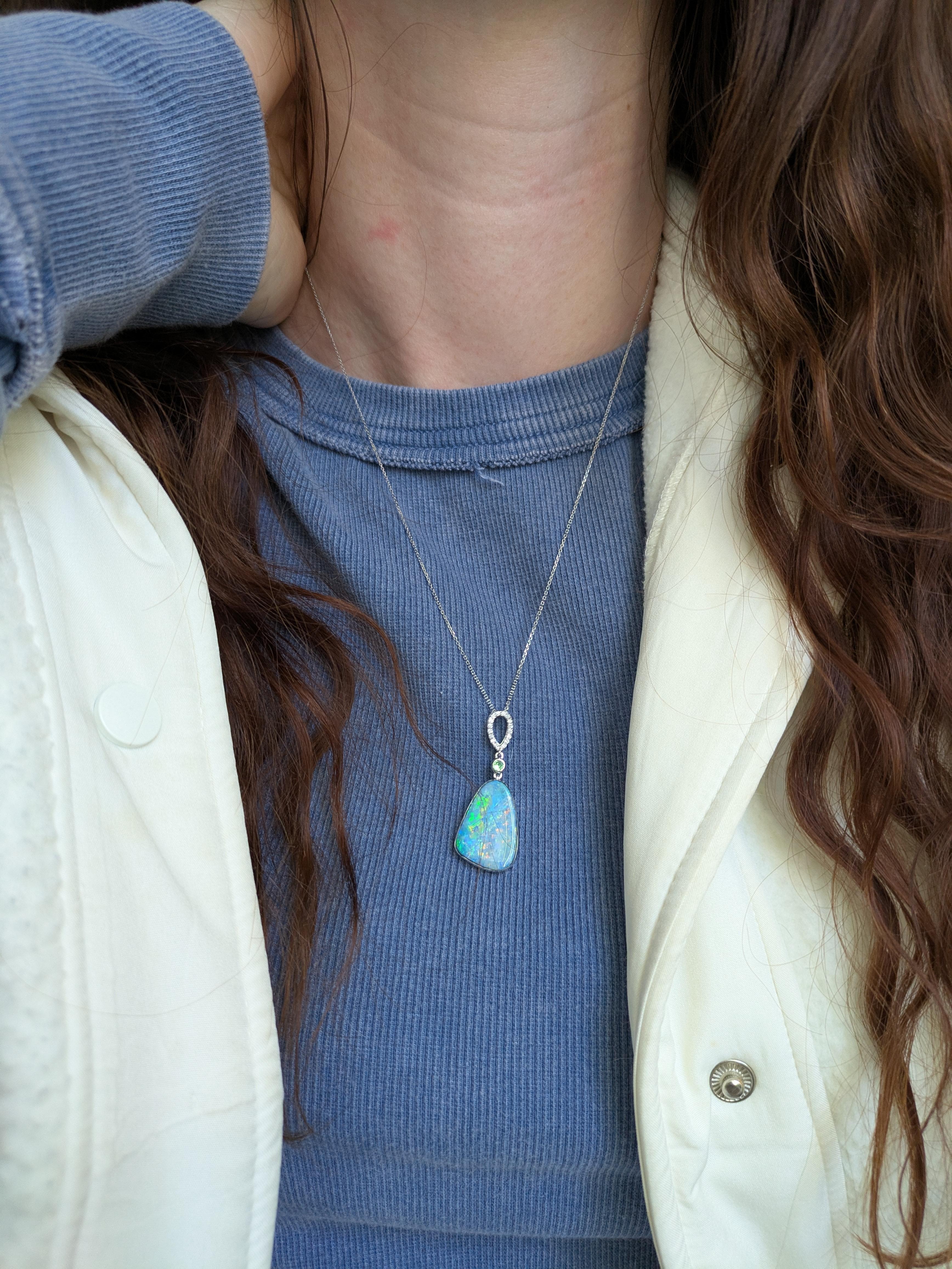 A captivating 11.31-carat boulder opal pendant shines with vivid hues, framed by a pave diamond bail of earth-mined diamonds. Crafted in solid 14k real gold, this large pendant offers a perfect blend of organic beauty and sophisticated sparkle,