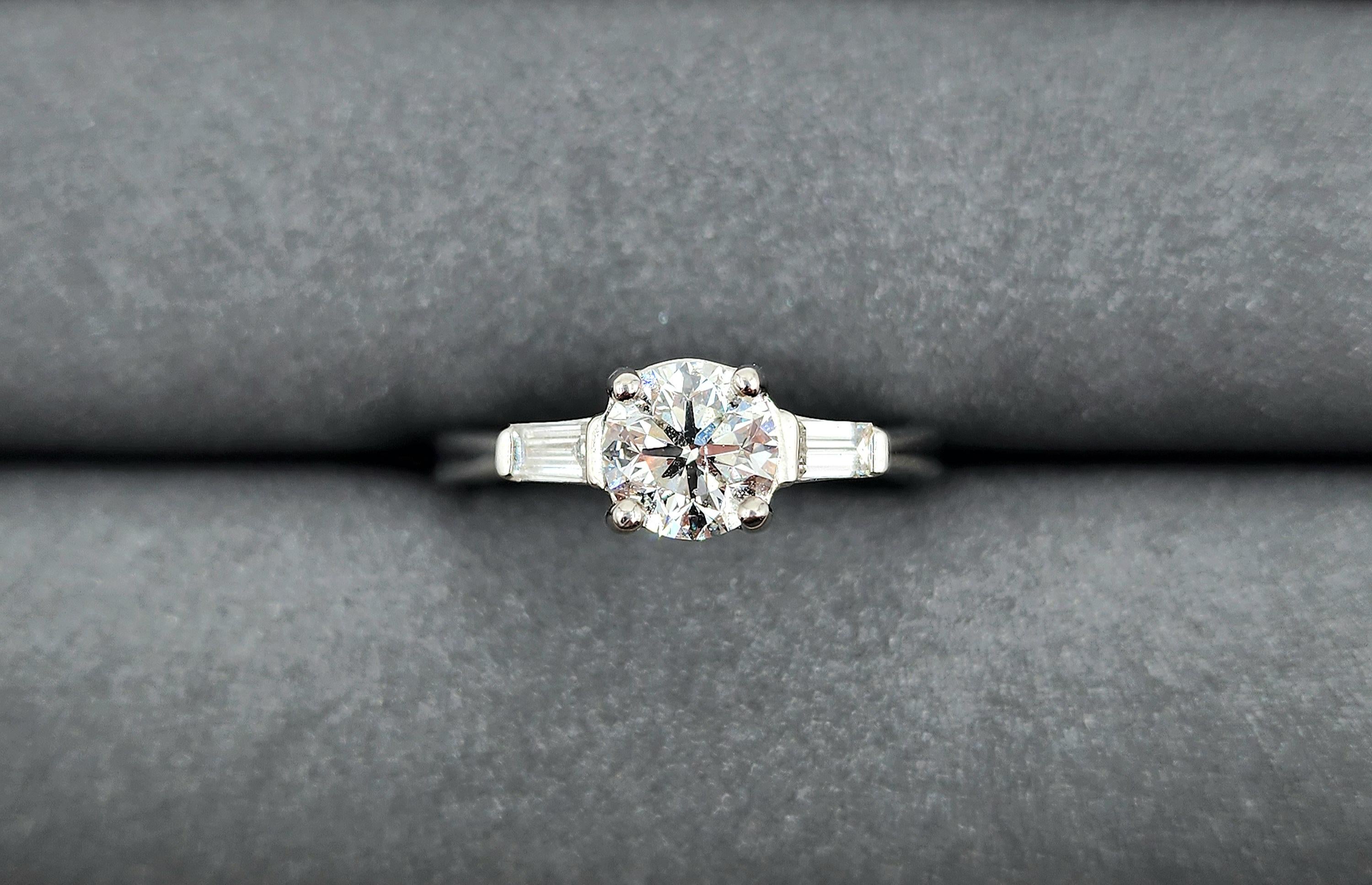 This gorgeous ring features a center diamond weighing 0.93 ct and two diamonds on the side weighing 0.20 ct set in platinum.  A beautiful engagement ring for any finger!