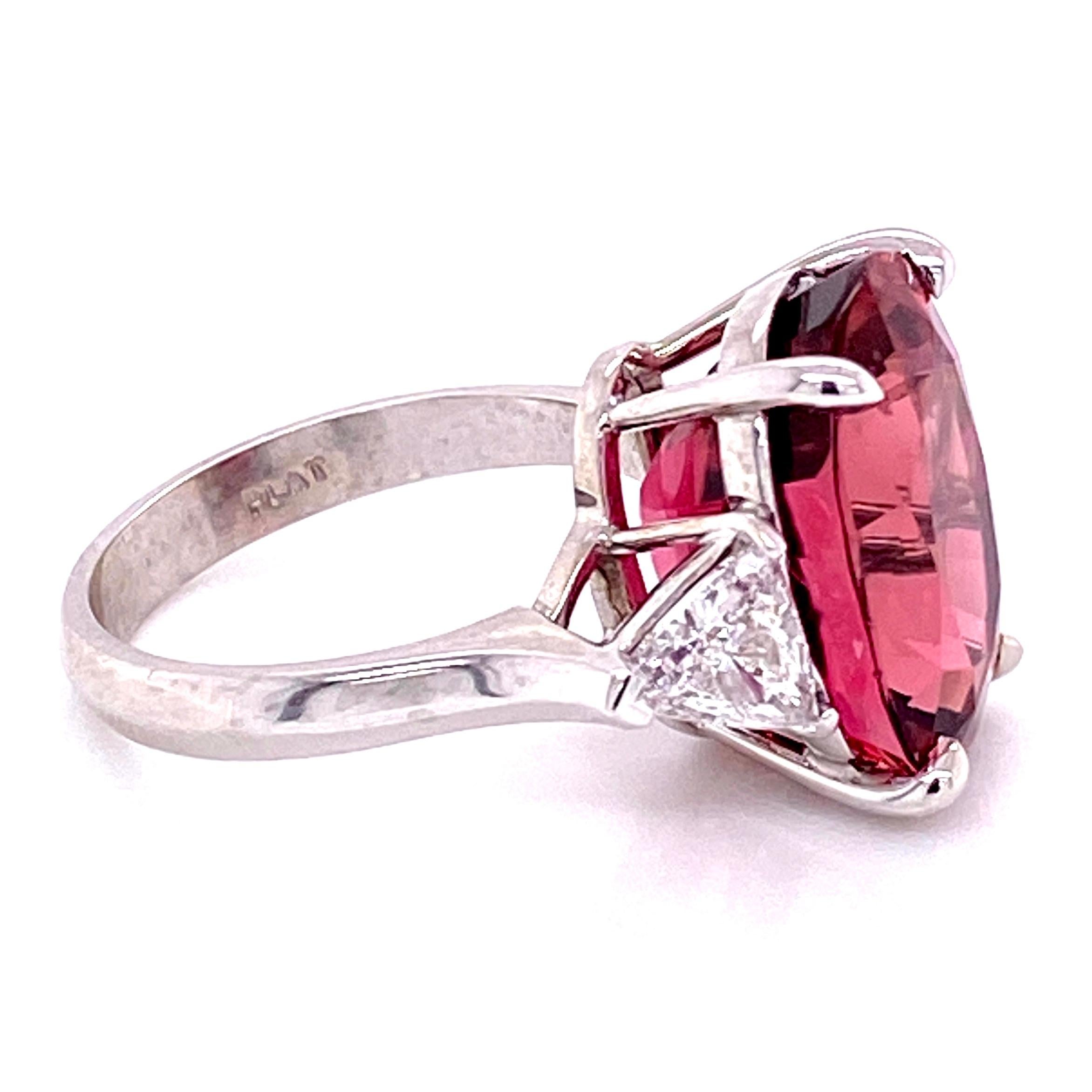 Simply Beautiful! Rubelite Tourmaline and Diamond Cocktail Ring, centering a securely set Oval Rubelite Tourmaline, weighing approx. 11.31 Carat enhanced either side by Trillion Diamonds, approx. 0.98tcw. The ring is Hand crafted in Platinum. Ring