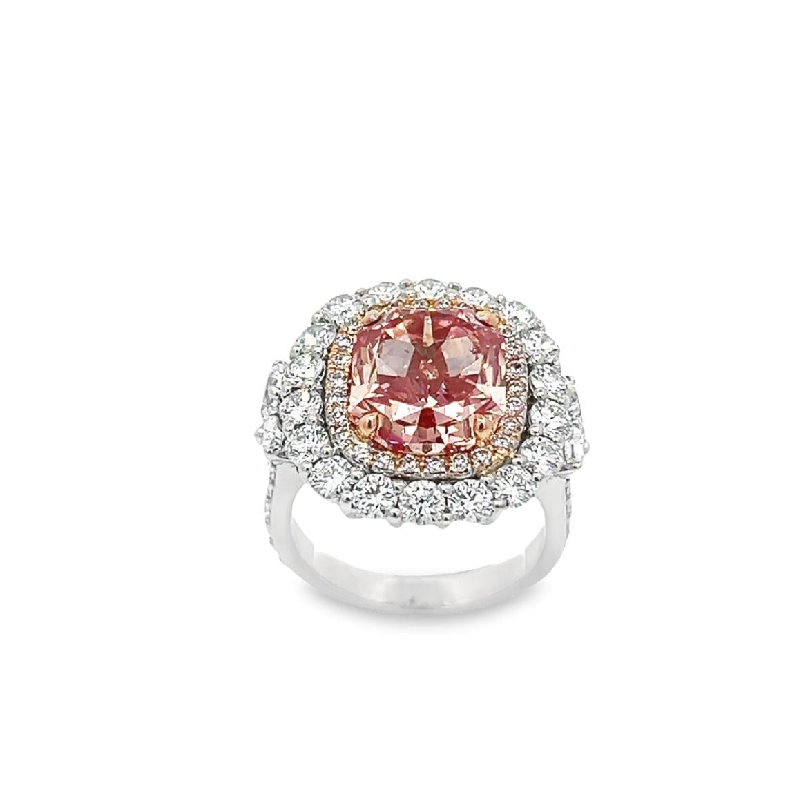 Introducing a truly remarkable one-of-a-kind ring that features a stunning 6.07-carat fancy vivid pink diamond with an SI2 clarity and a rectangular modified brilliant cut. The diamond is surrounded by dazzling round brilliant diamonds that come up