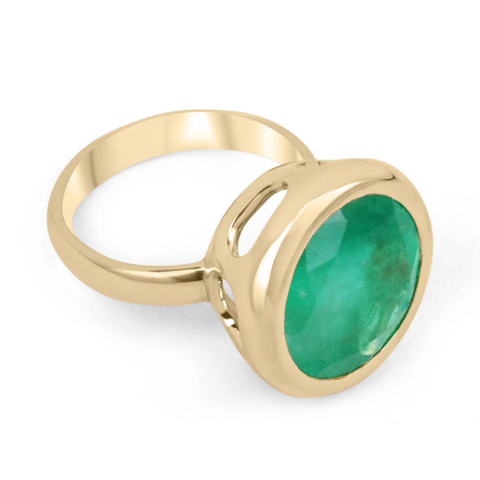 An exquisite Colombian emerald solitaire cocktail ring. Inspired by elaborate contemporary art, this piece shows how elegant simple can be. A large 11.33-carat, earth mined, round Colombian emerald sits delicately in a secure golden bezel. A rare